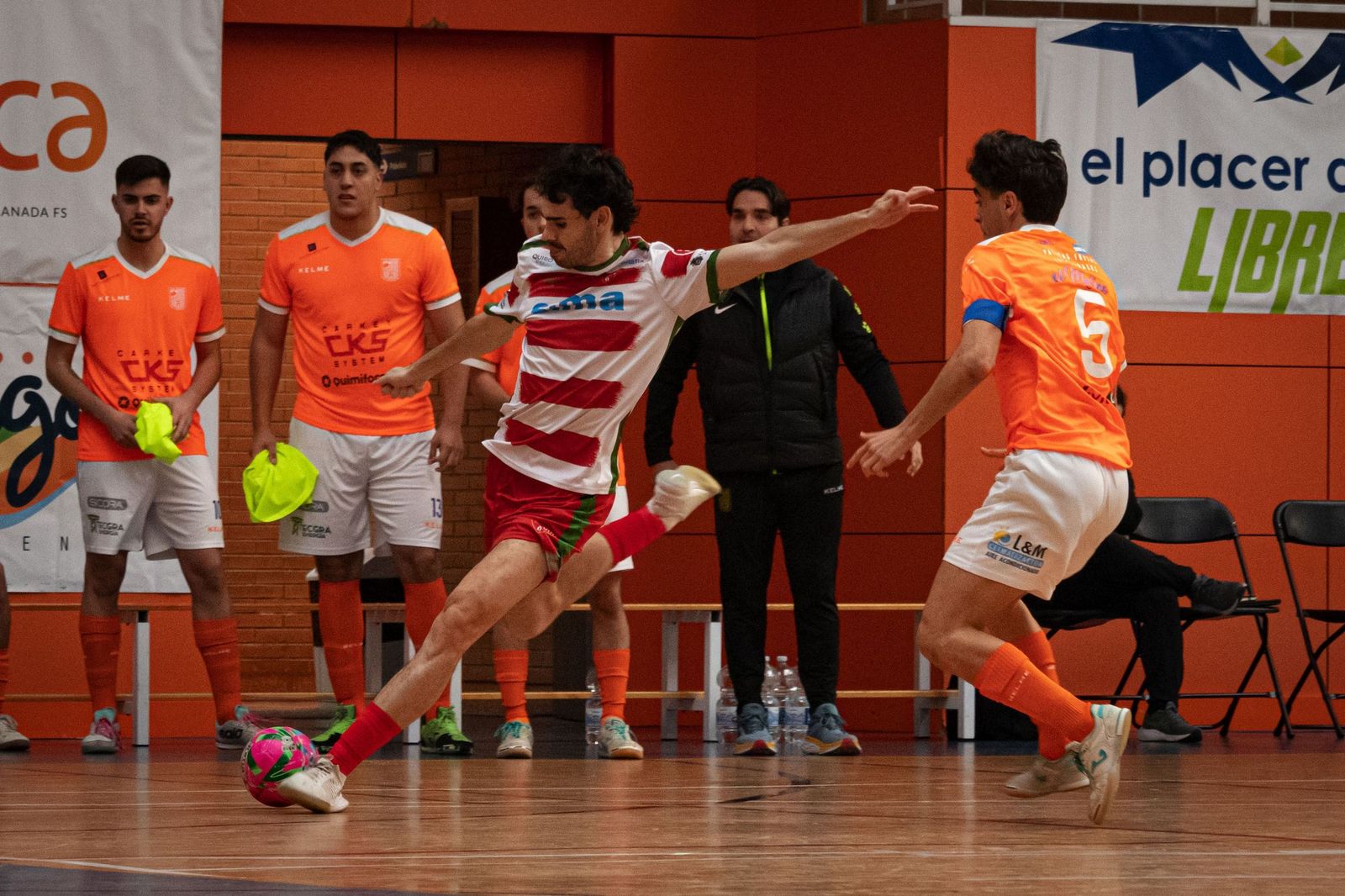 Un  jugador del Sima Granada golpea el balón ante la oposición de un rival.