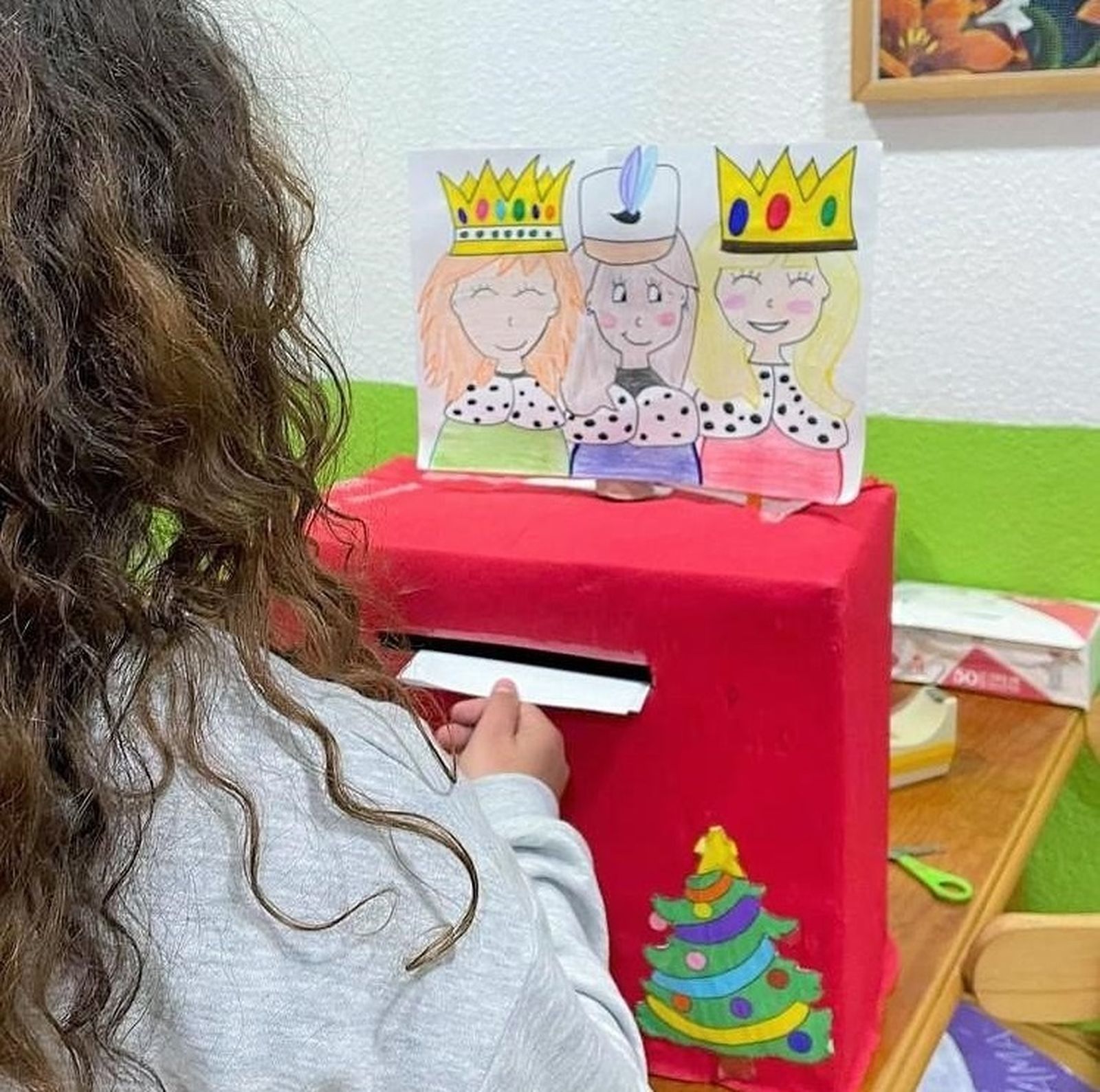 Imagen de una niña entregando una carta a los Reyes Magos en uno de los centros de acogida