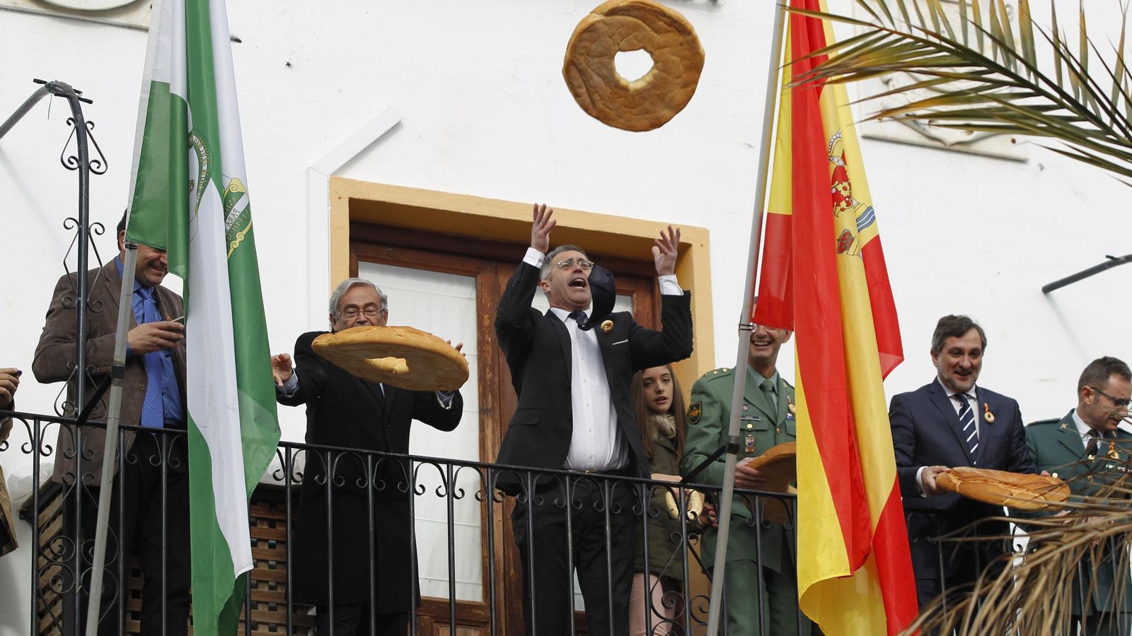 El regidor Antonio Pascual lanza un rosco desde el balcón del Ayuntamiento olulense.