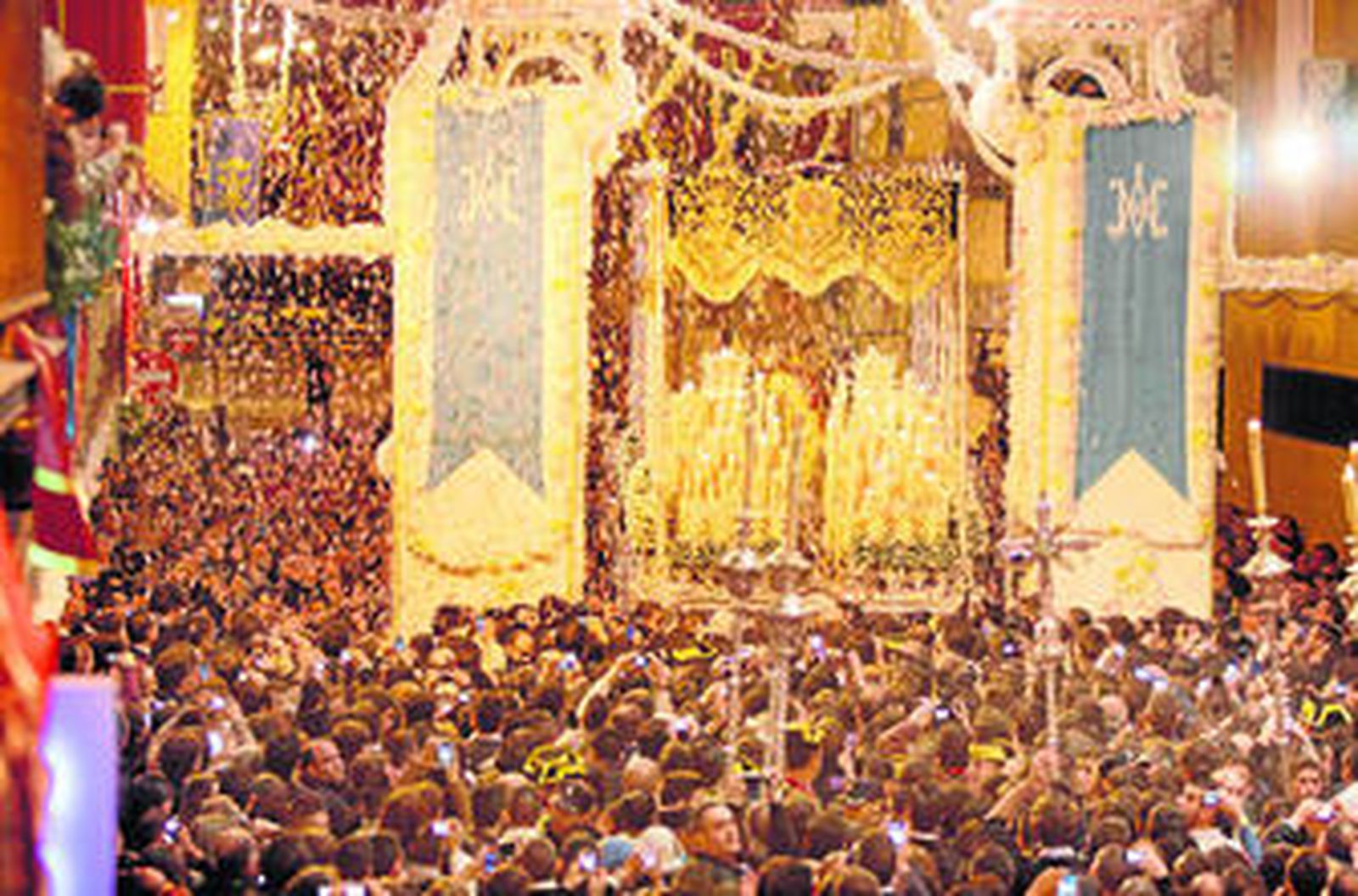 El paso del palio de la Virgen de la Victoria pasa debajo del arco traído desde Almonte y vestido con los gallardetes que acompañó al monumento a la Inmaculada en su bendición, en 2004.