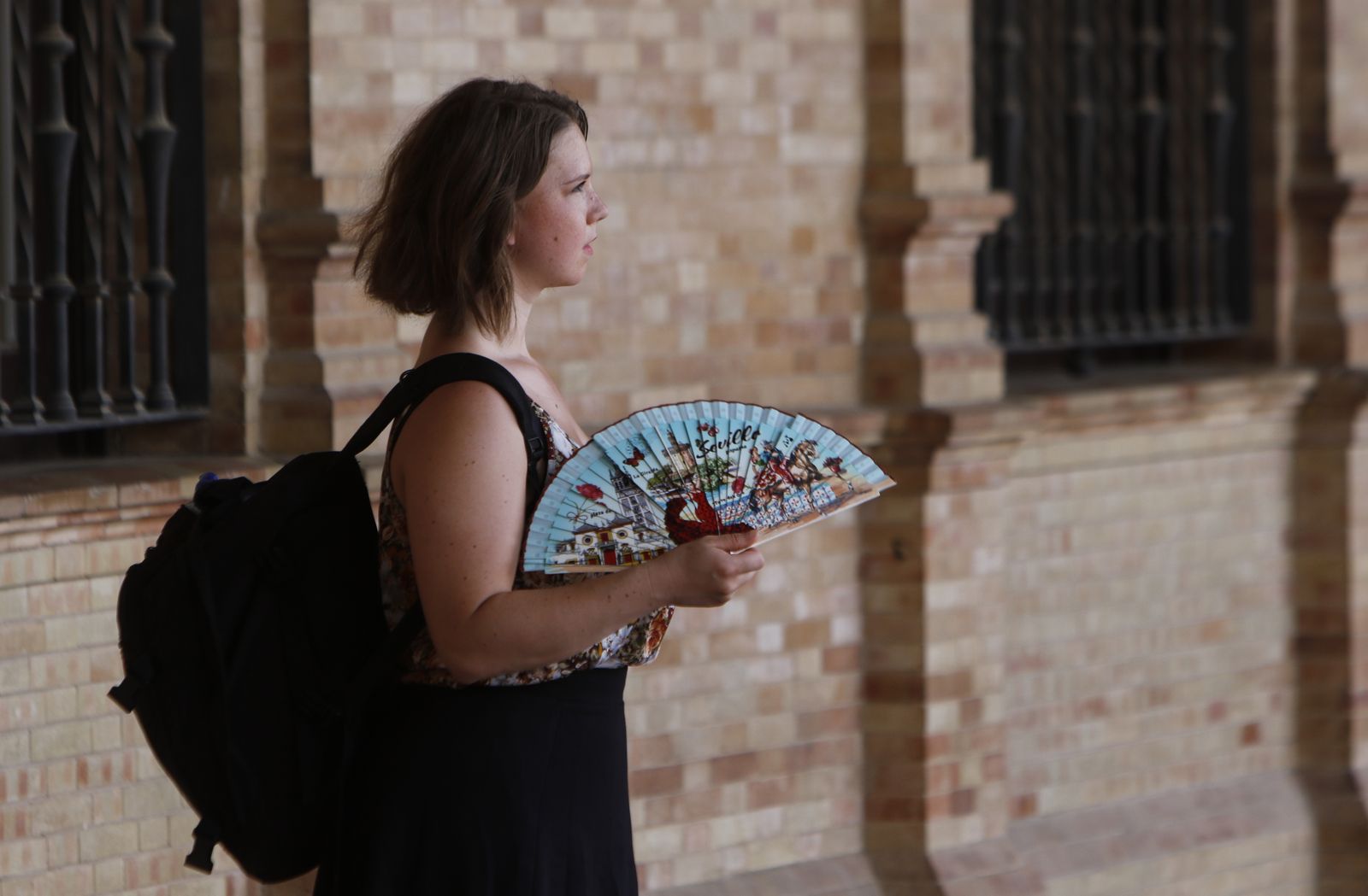 Una mujer, con un abanico en la Plaza de España.