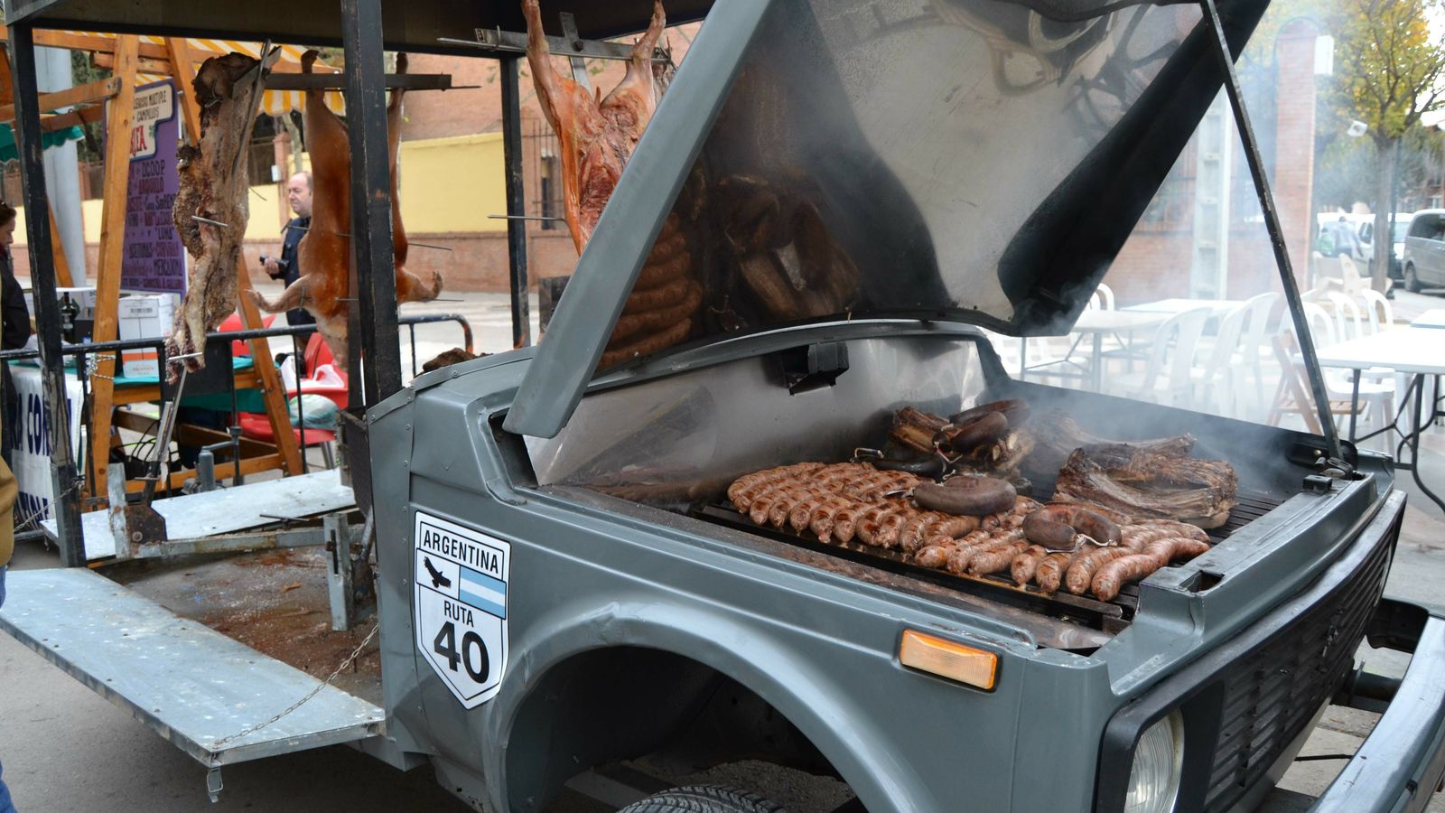 Una singular barbacoa en el capó de un coche.