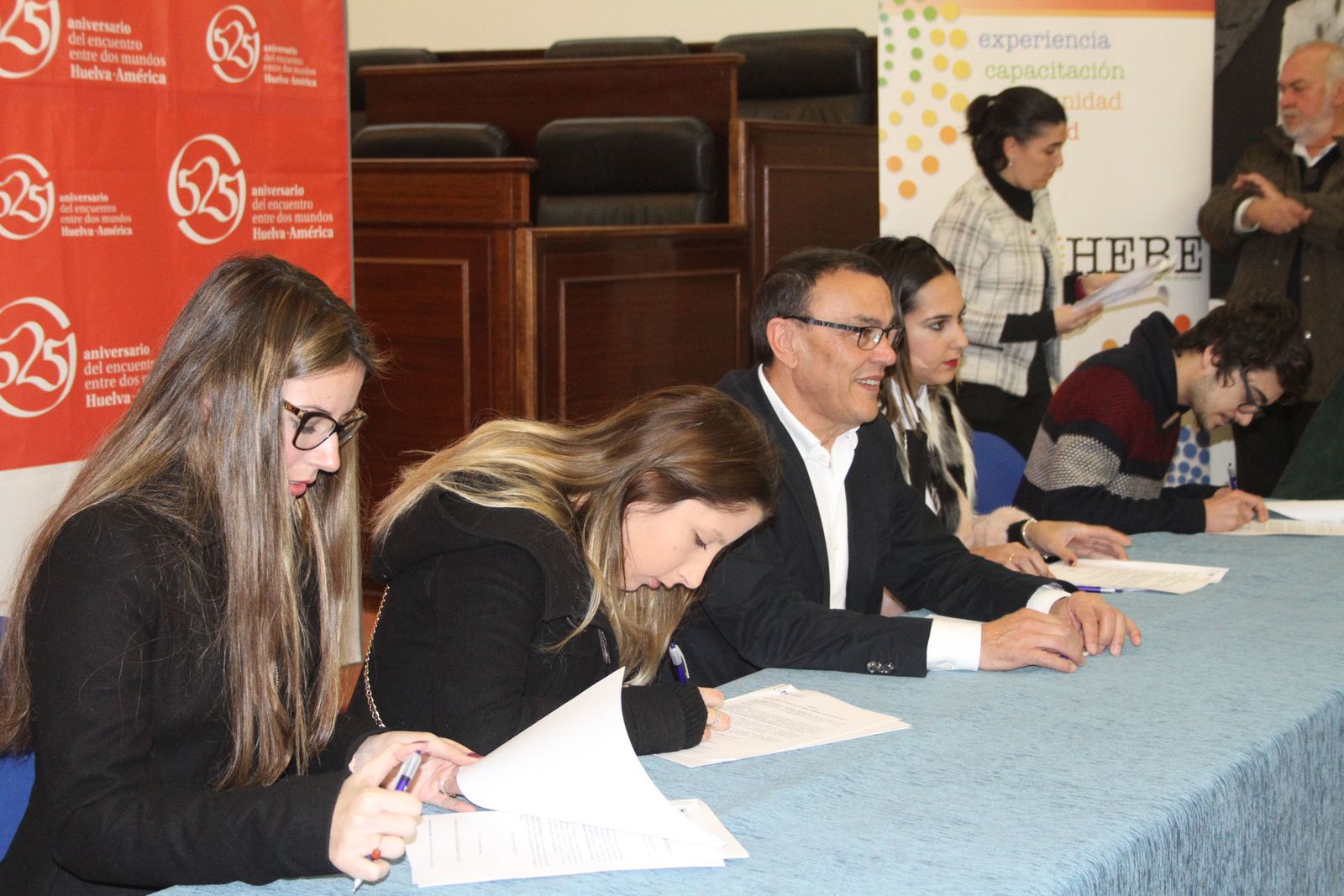 Varios jóvenes firman la beca del Plan HEBE junto a Ignacio Caraballo.