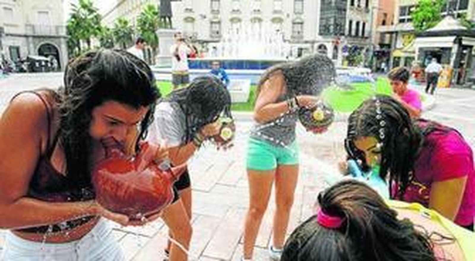 1, 3 y 4. Distintos momentos de la presentación ayer de la Fiesta de Los Jarritos en la Plaza de las Monjas de Huelva. 2. El diputado territorial de la Sierra, Ezequiel Ruiz, y el alcalde de Galaroza, Antonio Sosa, mojándose con los piporros.