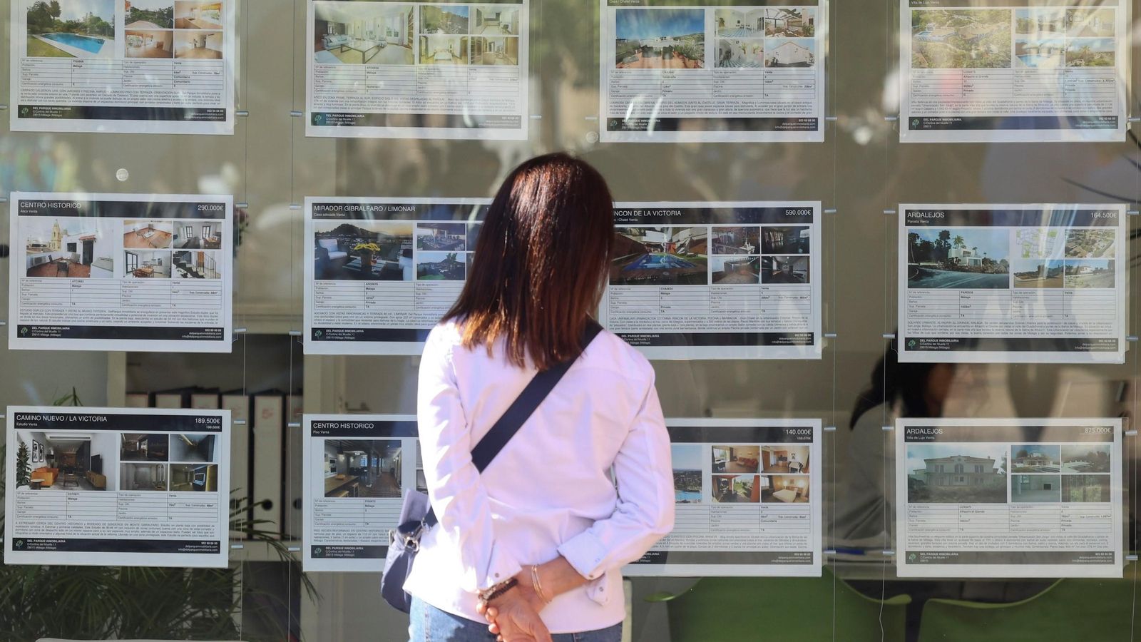 Una mujer mira los anuncios de una inmobiliaria