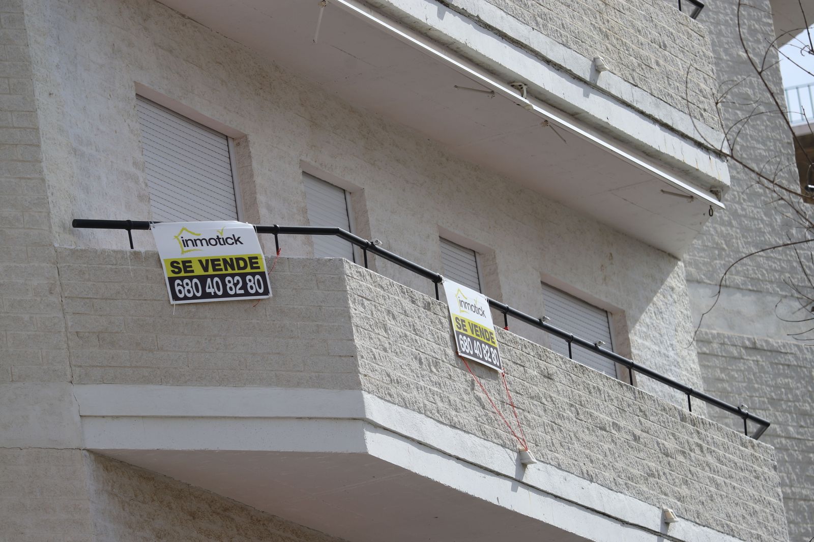 Balcón en un edificio de la capital con carteles de venta.