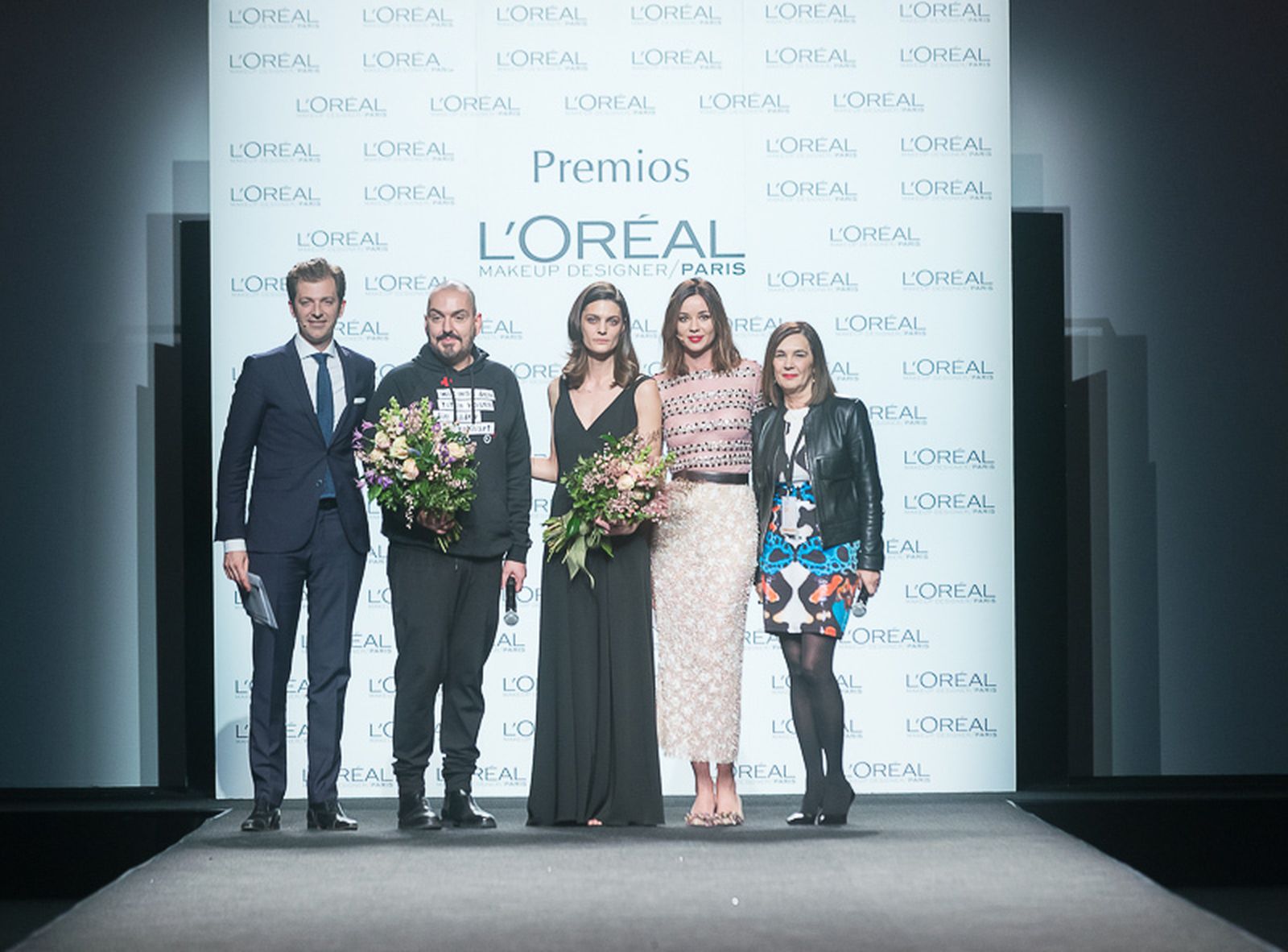Juan Duyos y Marina Pérez, ambos con ramos de flores, recogen el premio L'Oreal de este año.