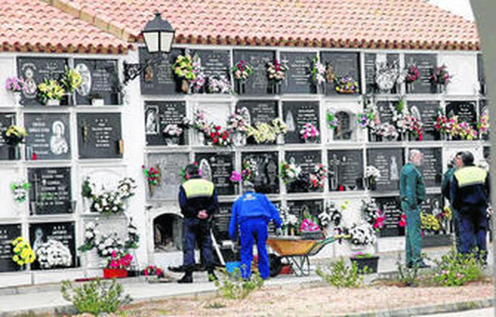 Los operarios reparan las tumbas, en presencia de Policía Local y Guardia Civil.