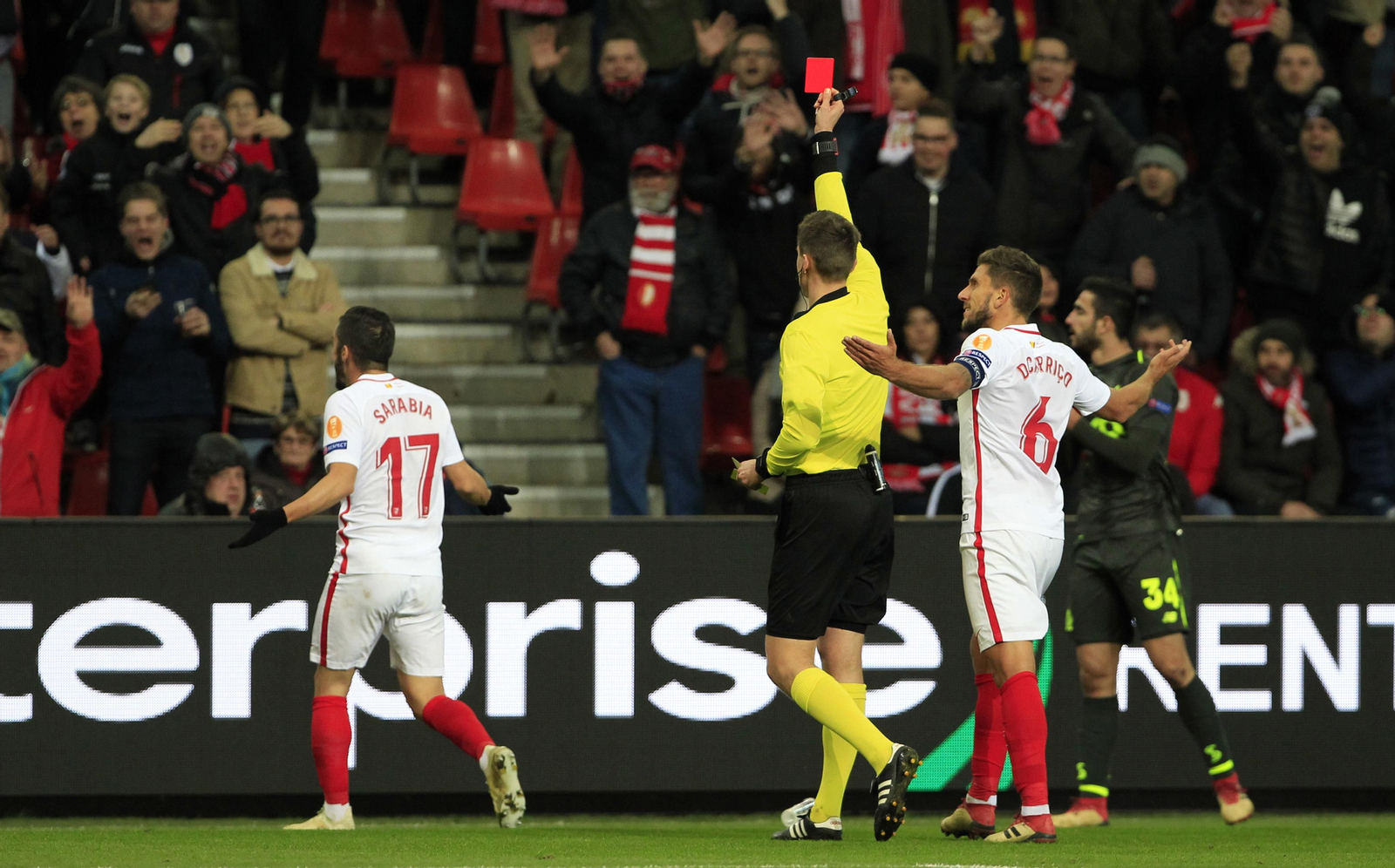 Sarabia pide explicaciones al asistente mientras el colegiado alemán Siebert le muestra la tarjeta roja, pese a las protestas de Carriço.