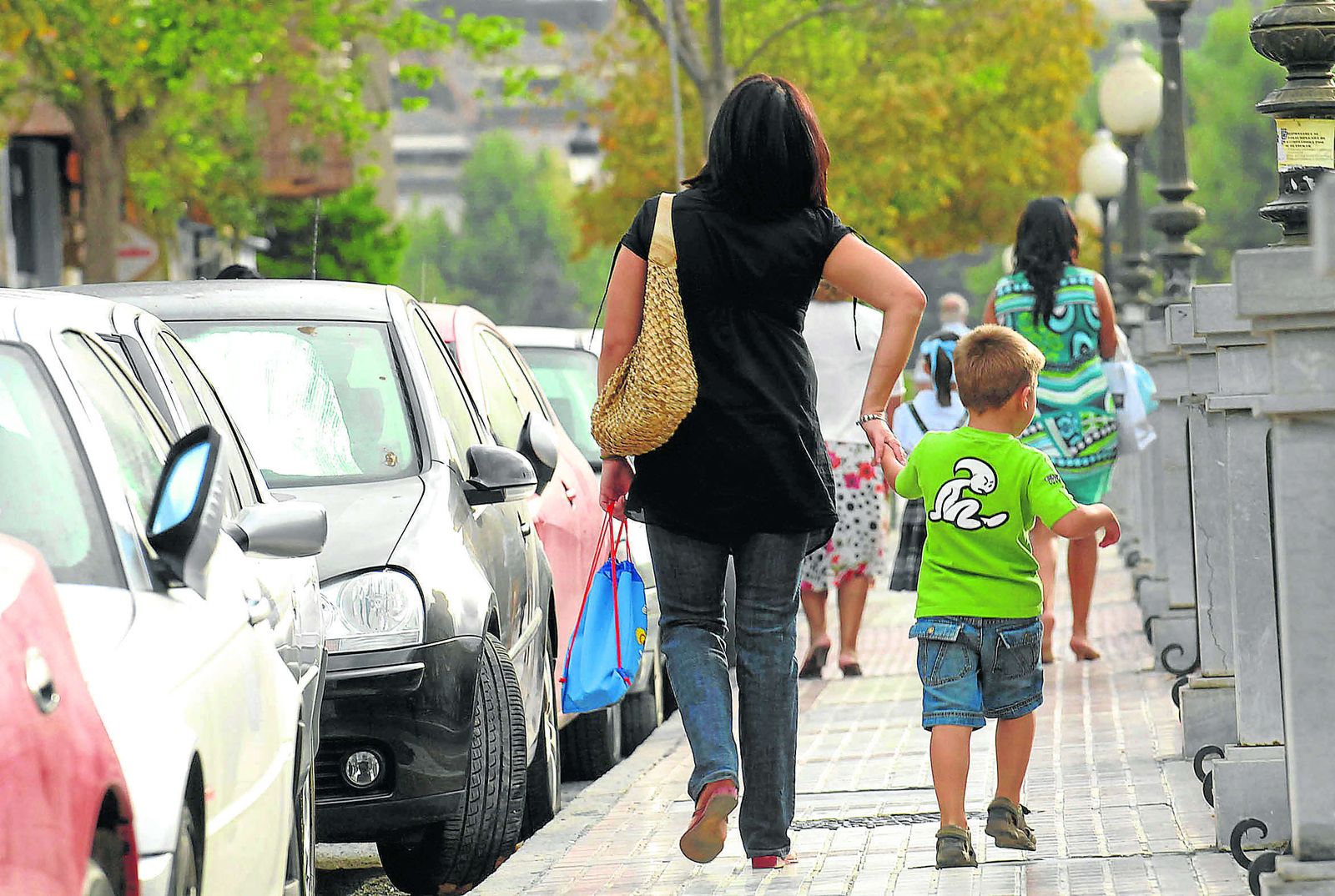 Imagen de archivo de una madre paseando con su hijo cogido de la mano