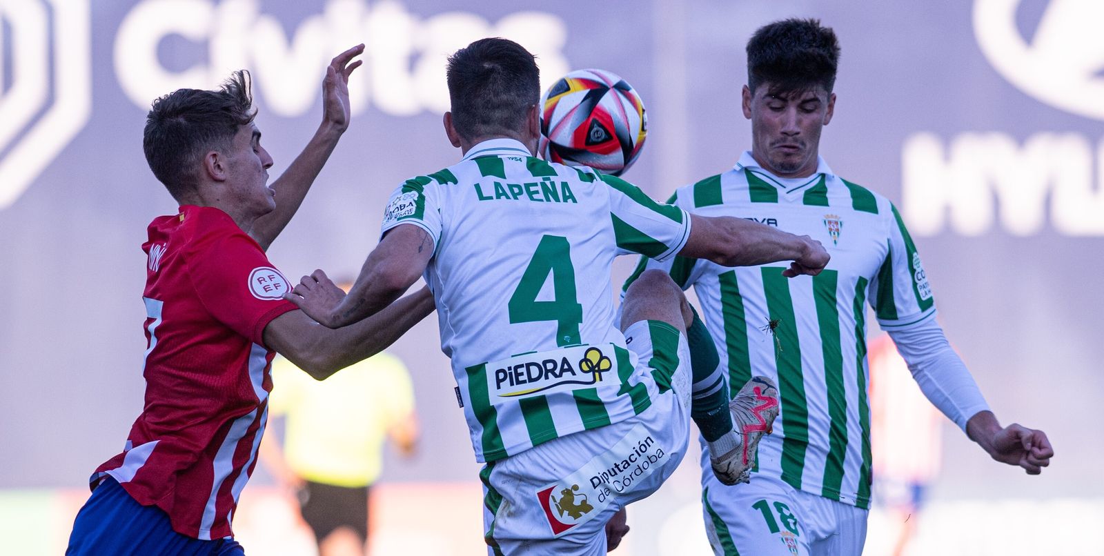 Los centrales del Córdoba CF, Lapeña y Carlos García, intentar despejar el balón en el partido ante el Atlético B.