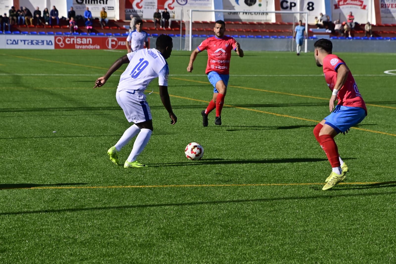 Peter Chikola avanza con el esférico en presencia de dos adversarios.