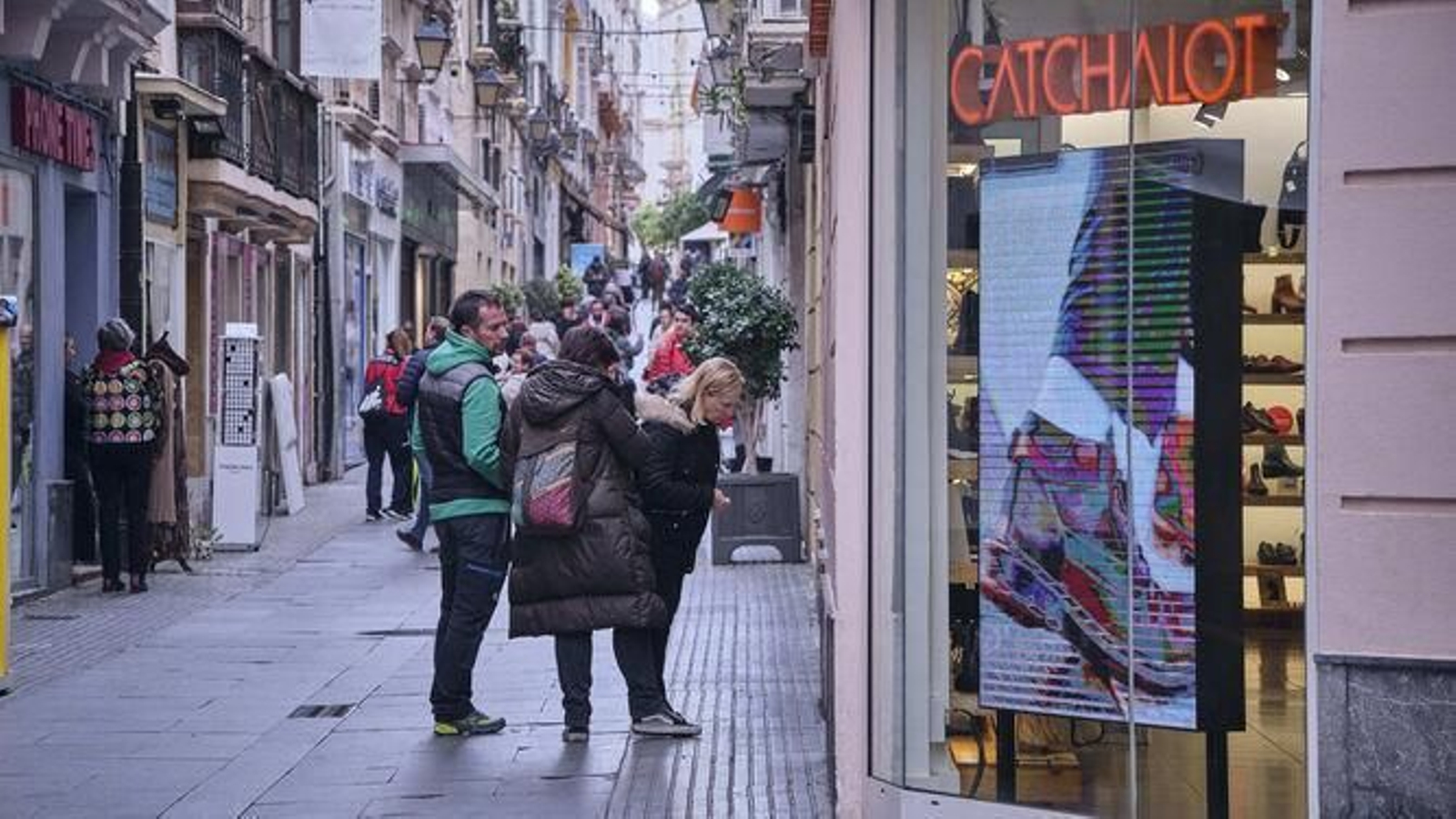 Un grupo de persona mira escaparates en una de las calles céntricas de Cádiz