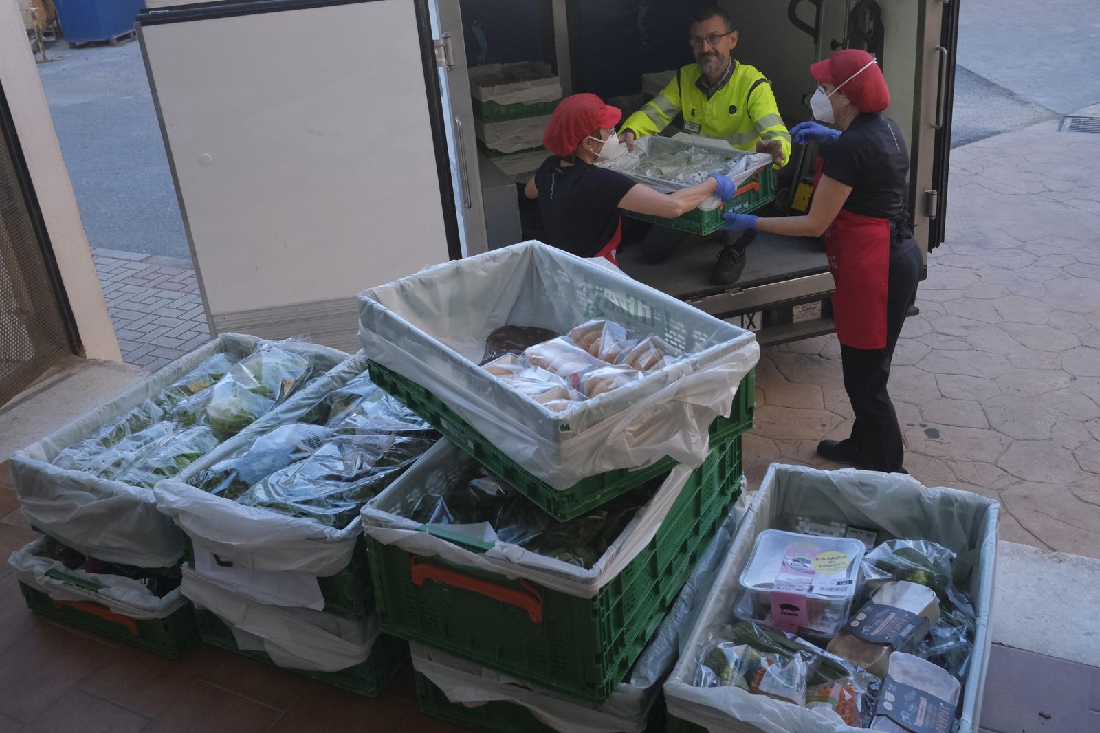 Cocineras de El Buen Samaritano recepcionan los alimentos.