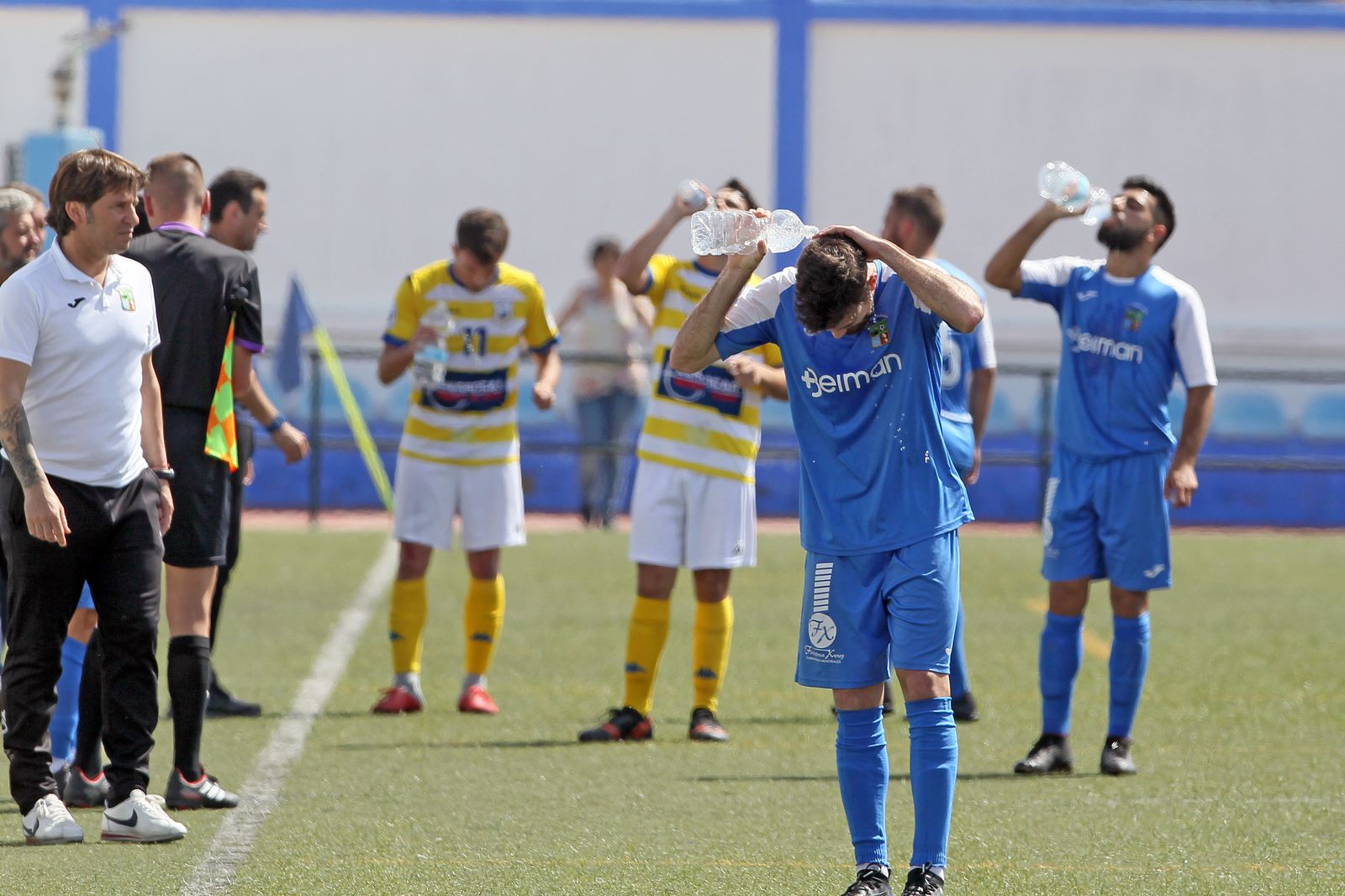 Mendoza observa a sus jugadores y a los del Coria refrescándose.