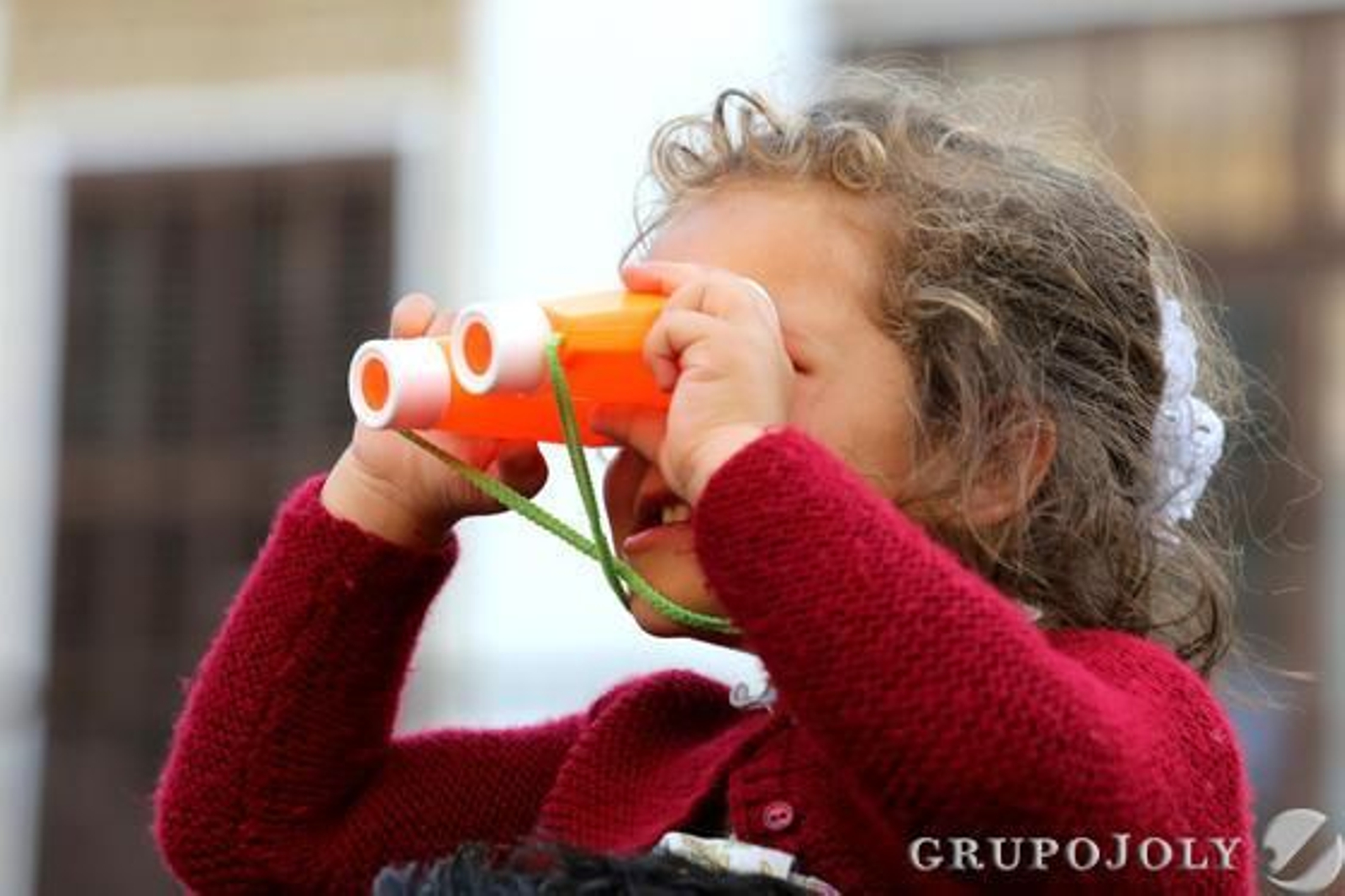 Una niña utiliza unos prismáticos de juguete para ‘ver’ mejor las cofradías.

Foto: Pascual