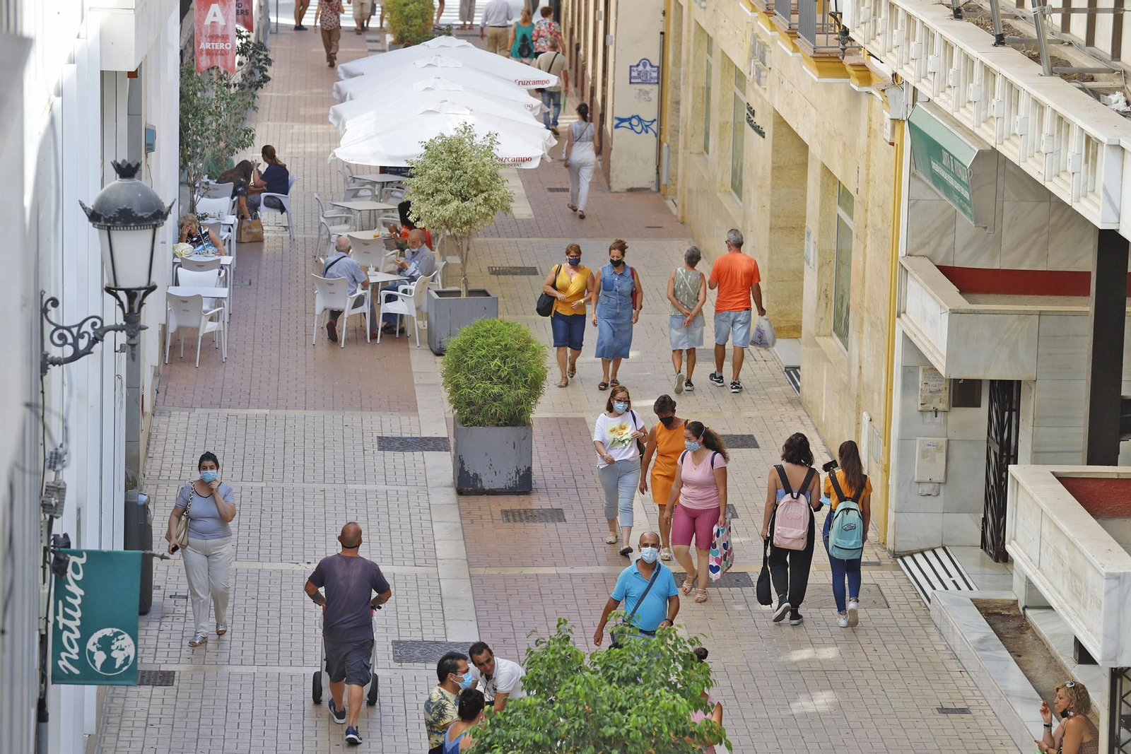 Ambiente en una calle céntrica en la que la mayoría de personas mantienen la mascarilla.