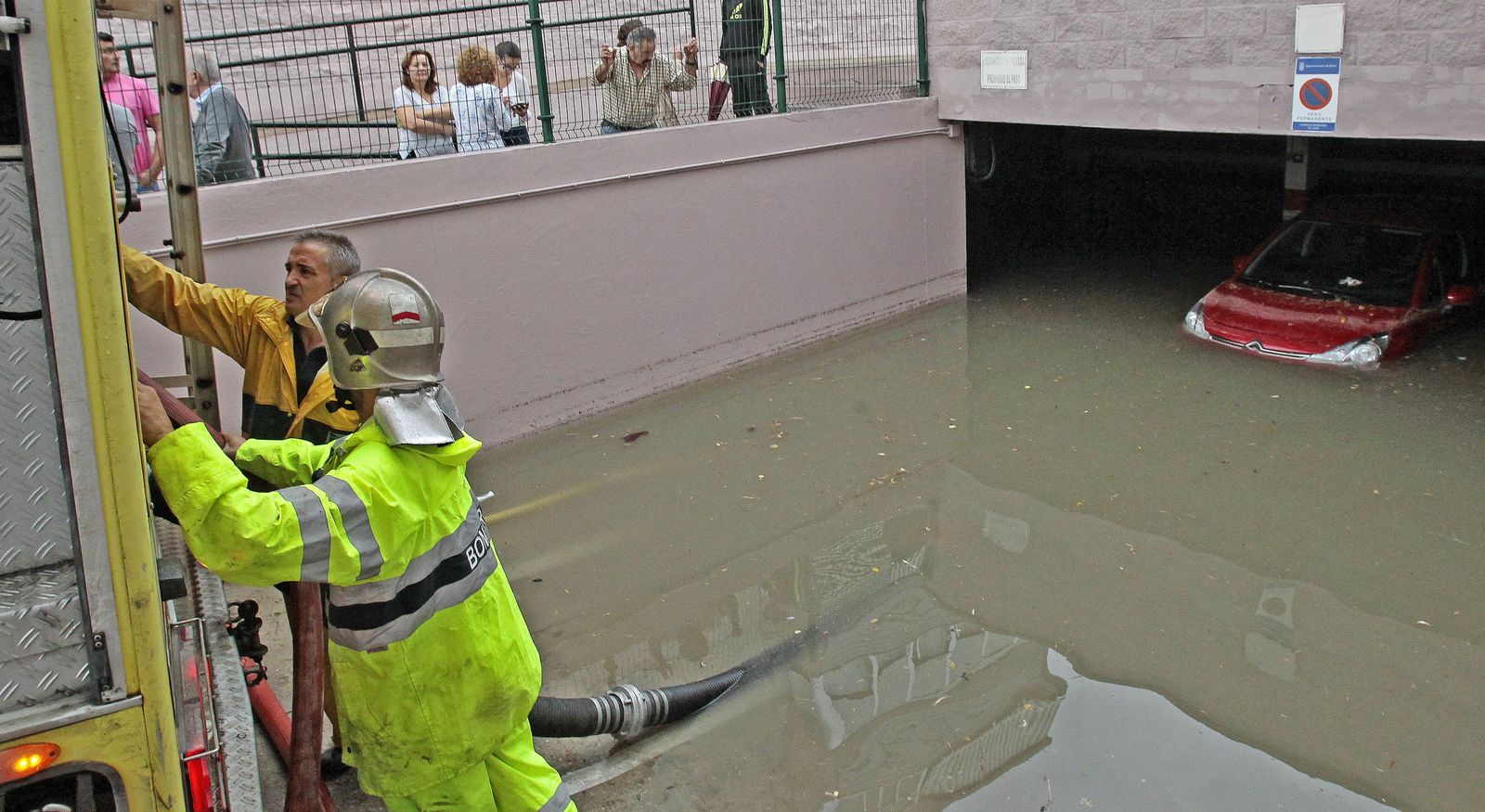 Bomberos bombean hacia la calle el agua del parking de La Liberación II, en la mañana de ayer.