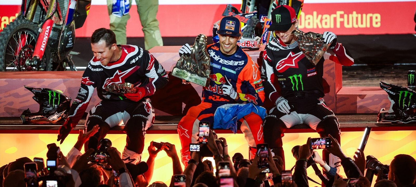 Brabec, Benavides y Schareina reciben sus trofeos en el podio final de las motos.