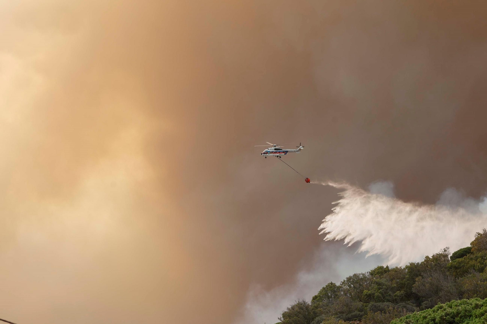 Una aeronave del Infoca vierte agua sobre uno de los focos.