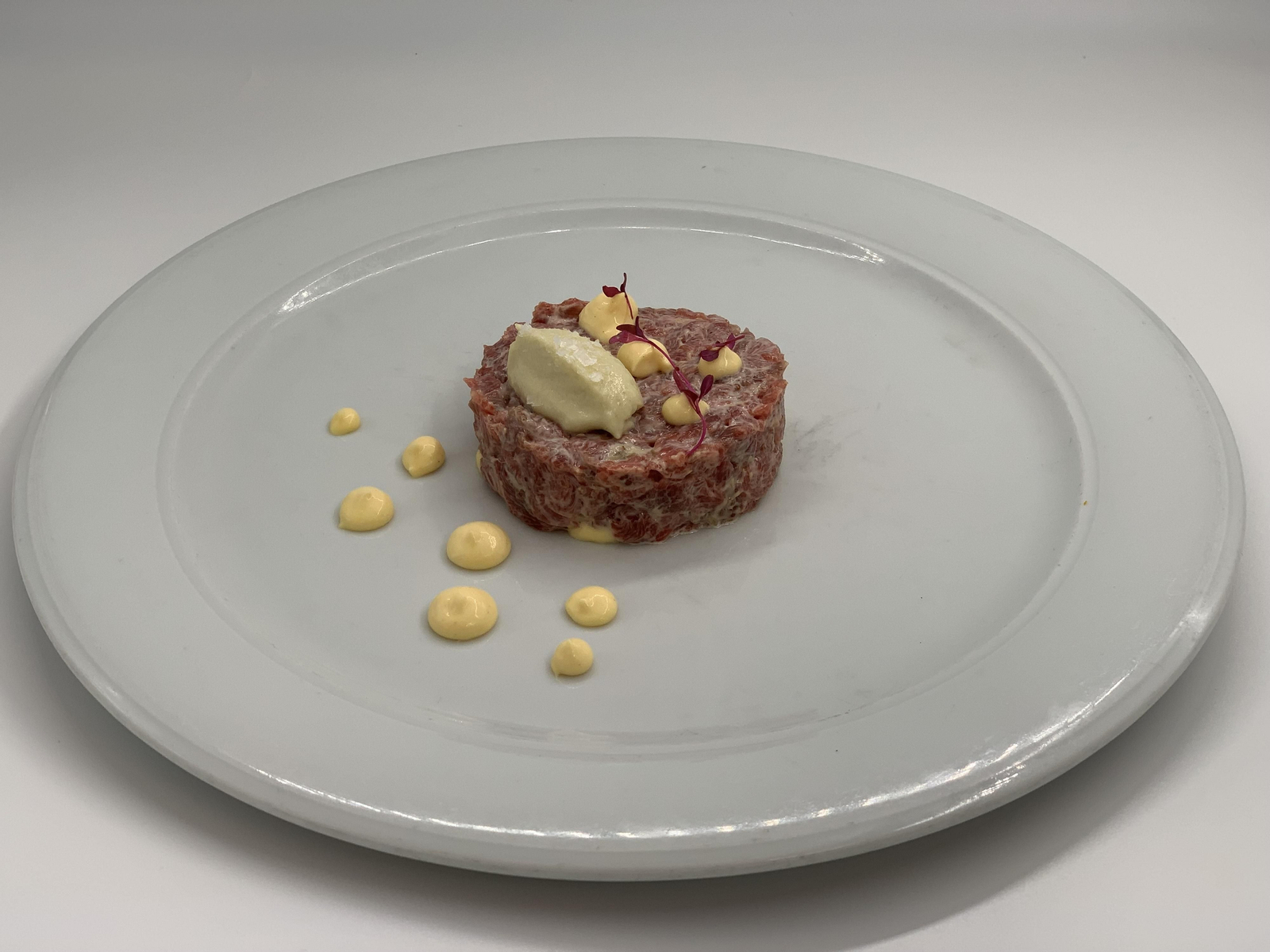 Steak tartar con aderezo de anchoa, cremoso de parmesano y gel de yuzu
