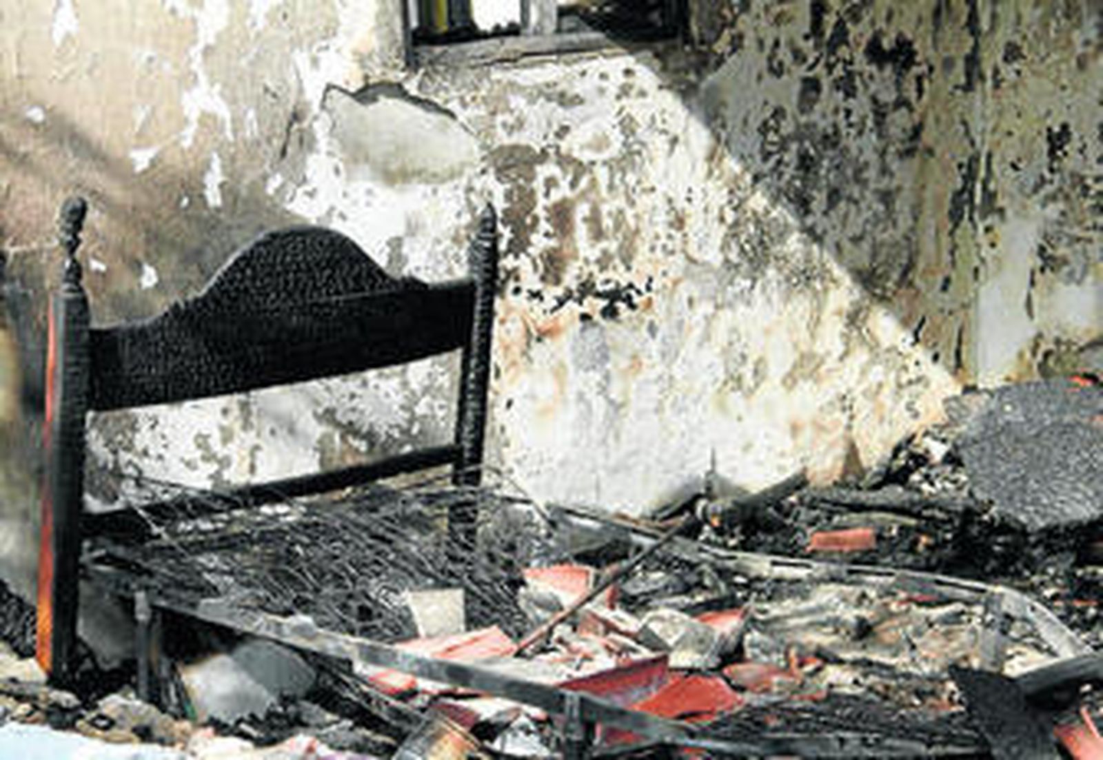 Imagen del dormitorio en el que comenzó el fuego, tras ser sofocado el incendio.