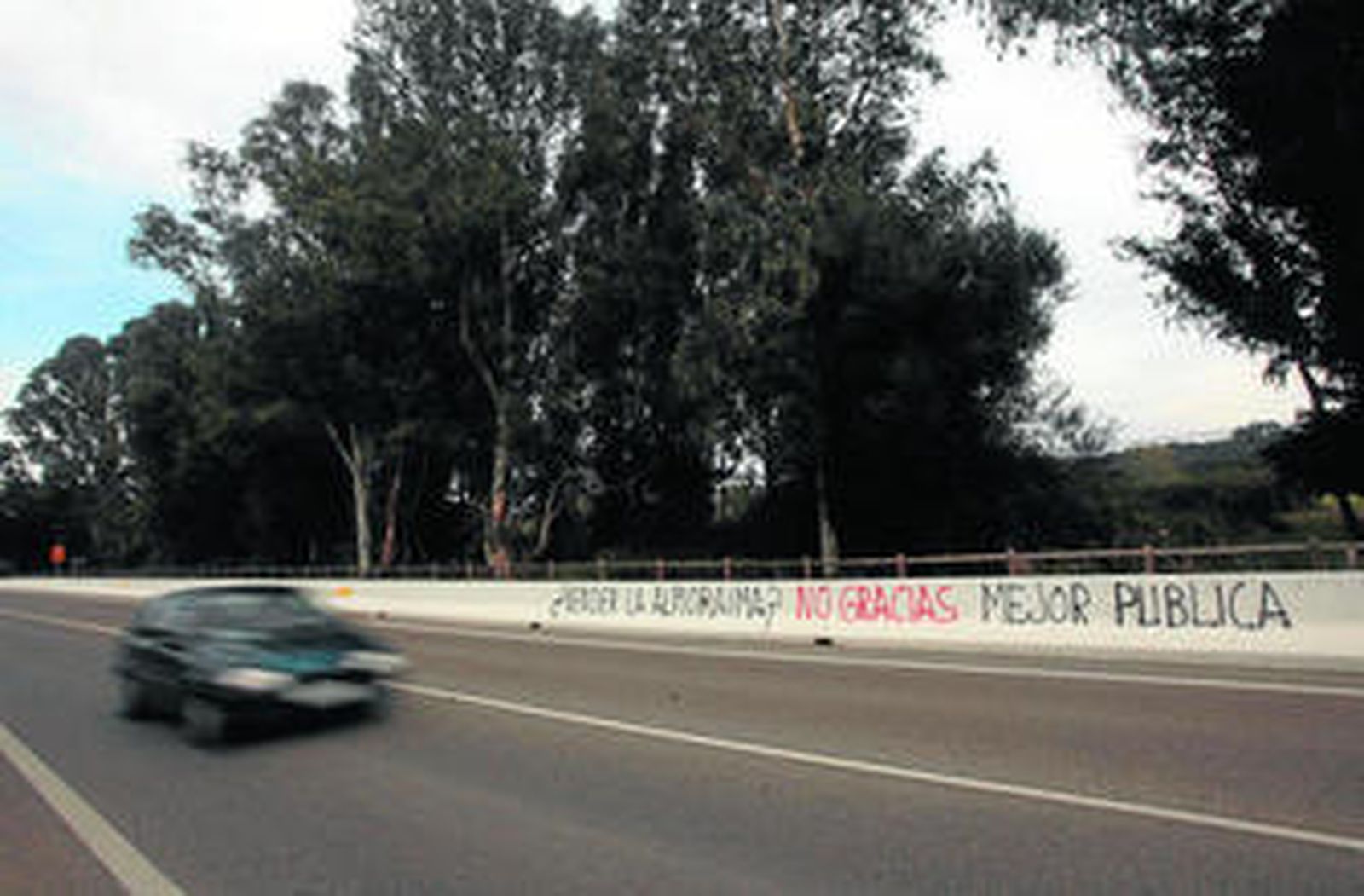 Una pintada contra la venta de La Almoraima en la barrera de protección de la A-405, ayer por la mañana.