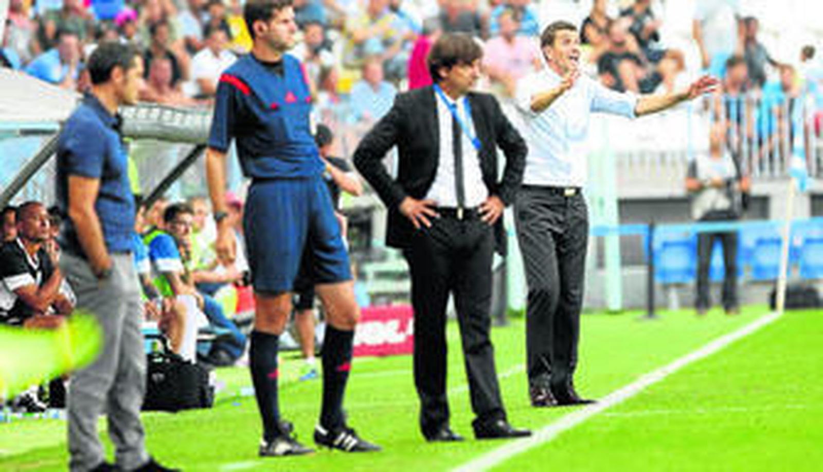 Javi Gracia, al fondo de la imagen, dando órdenes en el Málaga-Athletic de Bilbao de la primera jornada de Liga.