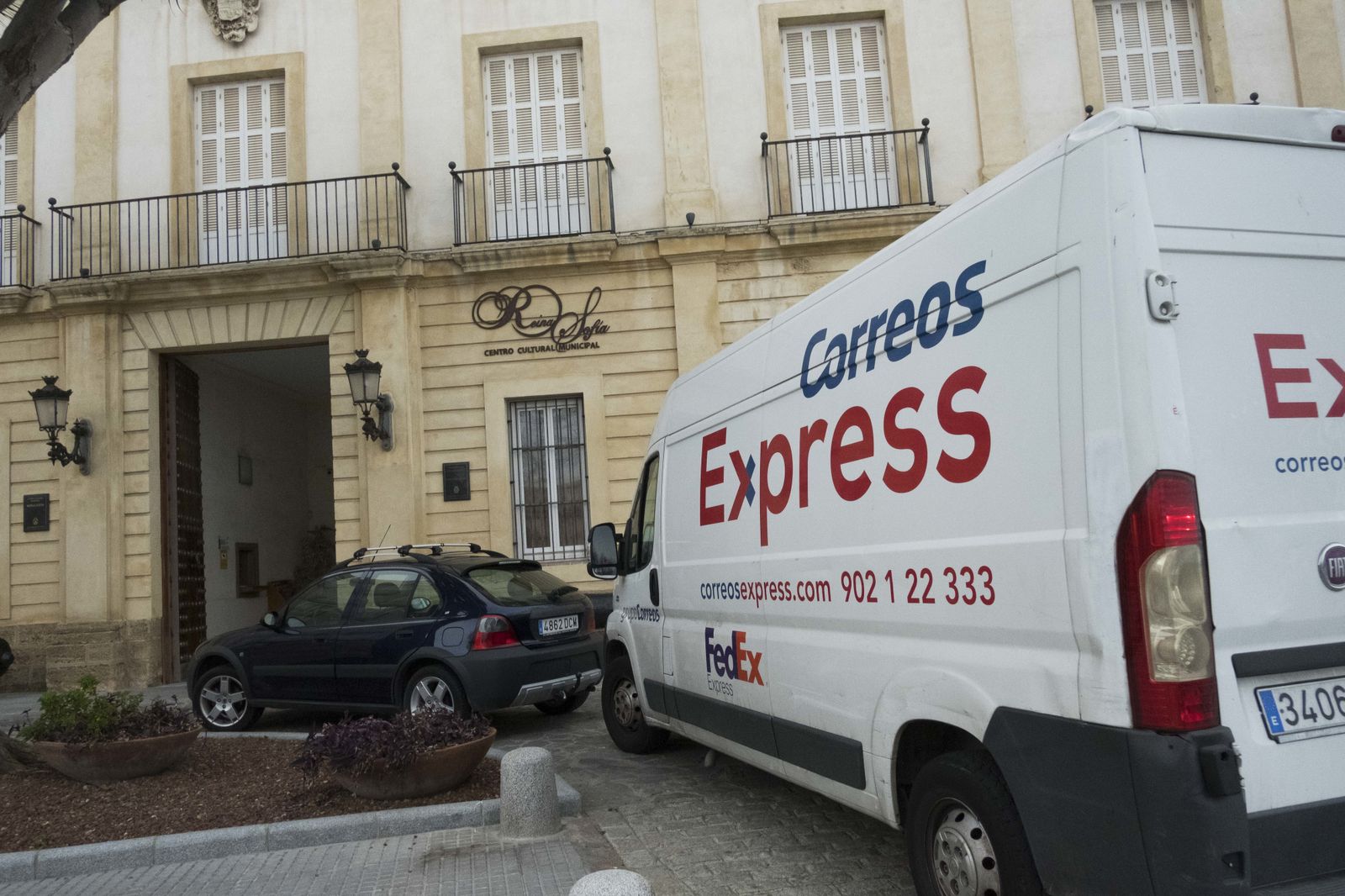 Fachada del Reina Sofía, con varios vehículos de transporte aparcados delante