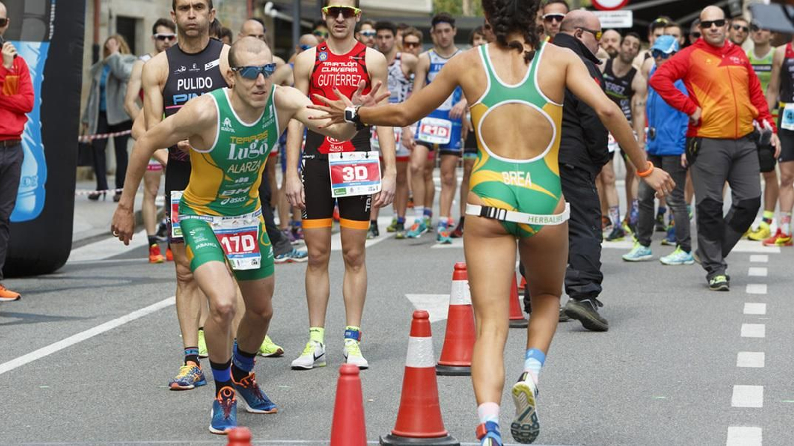 Dos atletas se dan el relevo en una prueba de duatlón mixto.