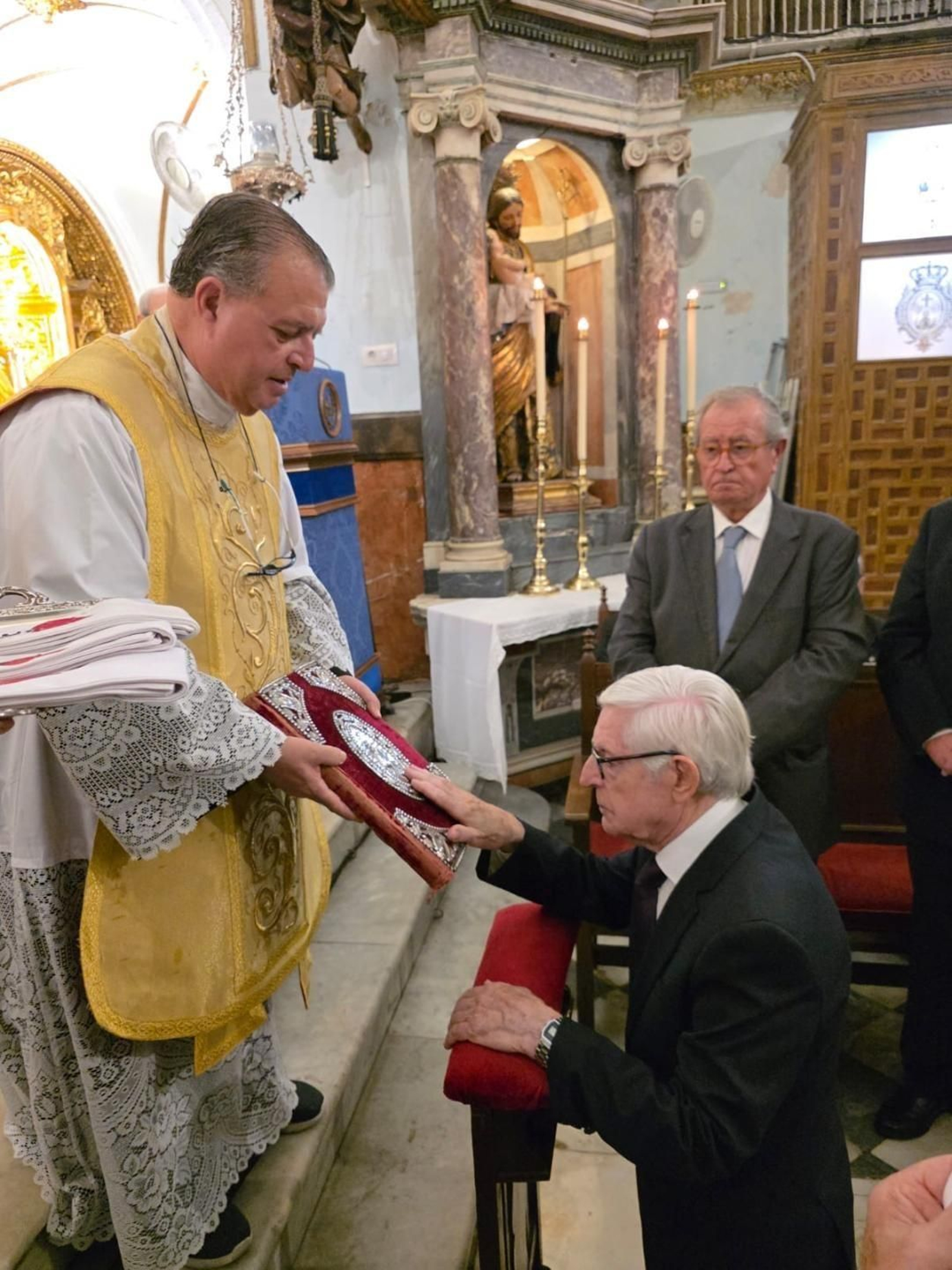 El padre Miguel Ángel González con Joaquín Díaz durante su ingreso en la Hermandad de la Santa Caridad.