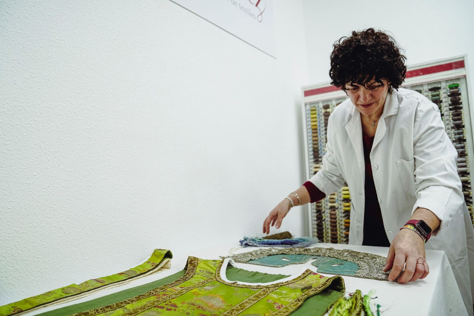 La conservadora supervisa el traje del Niño de la Virgen de Gracia.