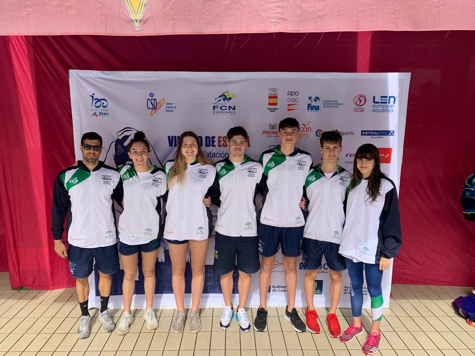 Un grupo de nadadores del CN Churriana durante una de sus competiciones junto a su entrenador, Alejandro Mateos.