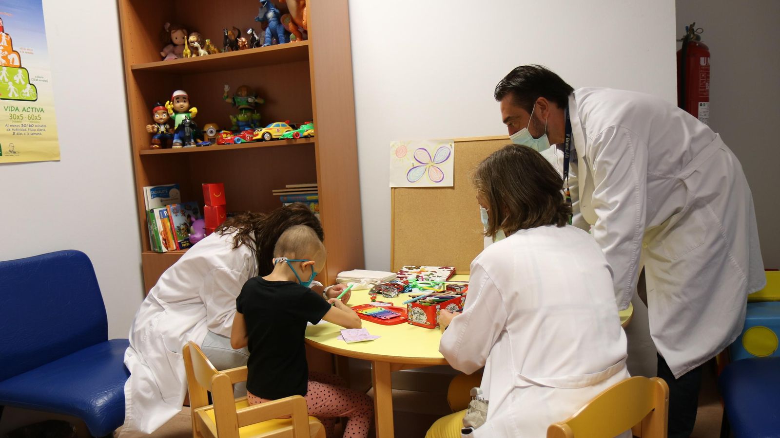 Los profesionales del servicio en la sala de espera junto a una menor en tratamiento.