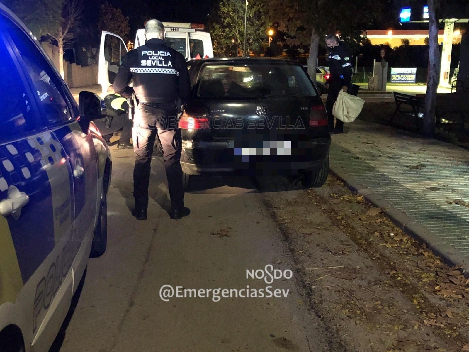 Un policía local de Sevilla, con el coche que protagonizó la persecución.