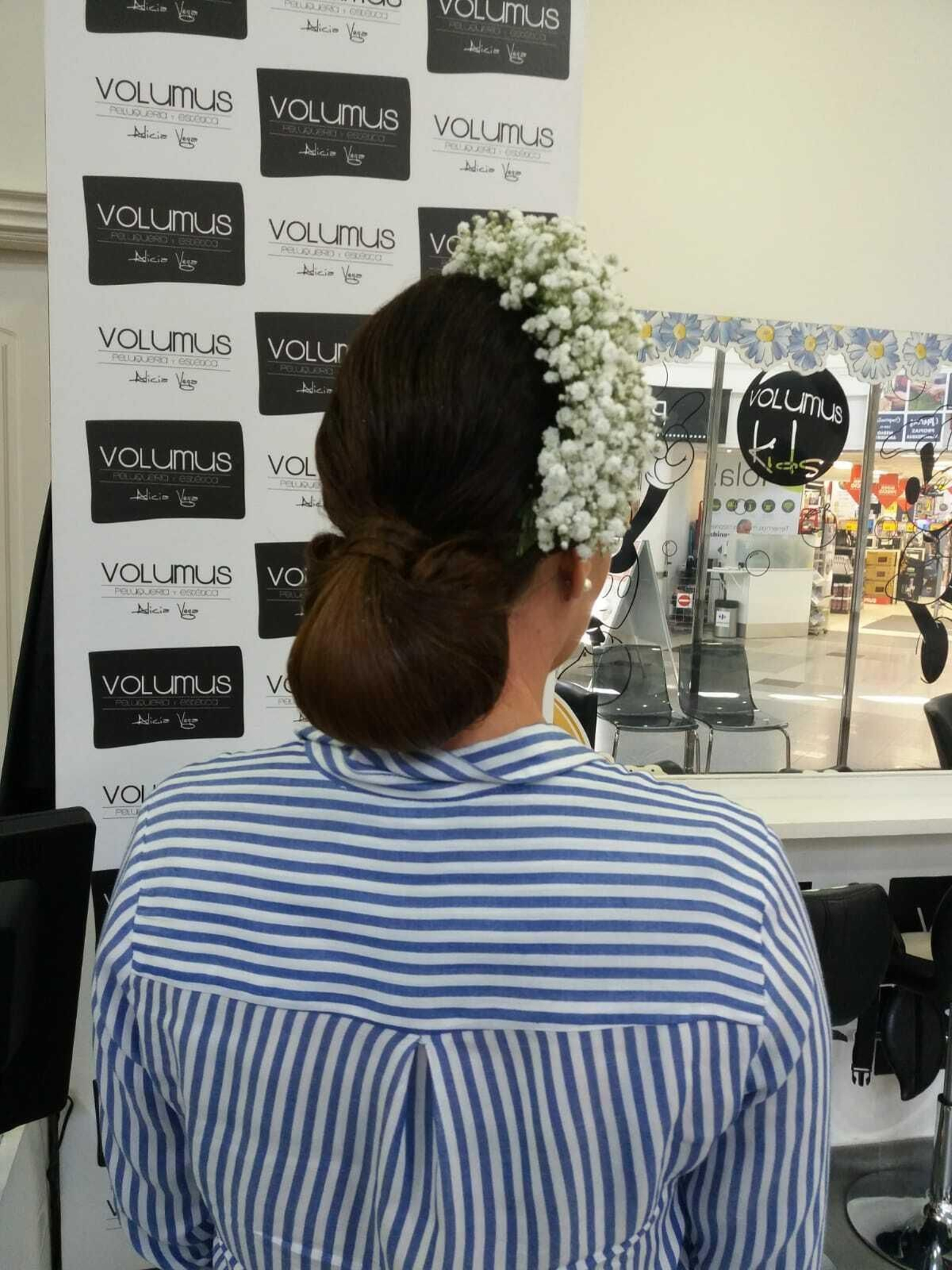 La castaña es uno de los peinados más fáciles y socorridos en esta fiesta. En la imagen se puede observar la propuesta realizada por la peluquería Volumus (en el centro comercial El Paseo), donde han optado por poner el ramillete de flores ladeado sobre la cabeza.