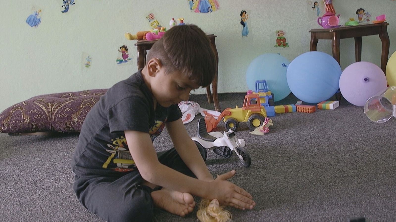 Imad, un niño adiestrado por el Daesh tras ser raptado, simula decapitar a una muñeca