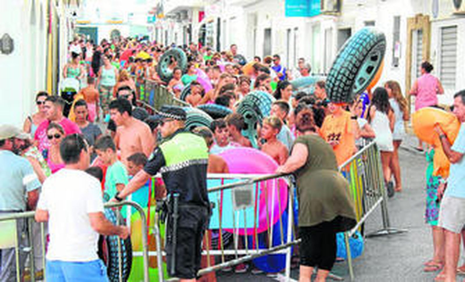 Varios cientos de personas guardaron cola antes de deslizarse por el tobogán gigante ubicado en la céntrica calle San Sebastián de Conil.