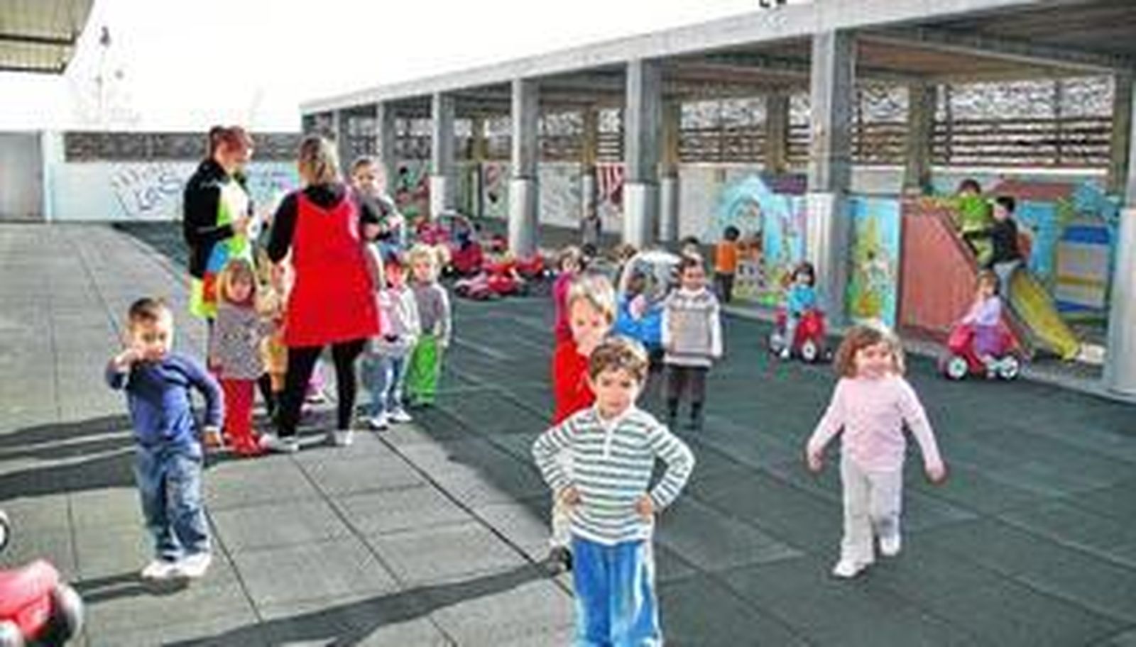 Los niños de 2 a 3 años en el patio exterior de juegos del centro escolar de la Universidad.