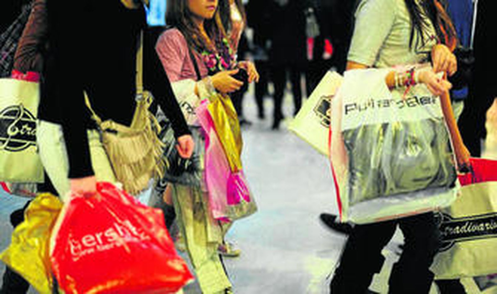 Unas clientas de Bahía Sur, cargadas con bolsas de compras, ayer en la primera jornada de rebajas.