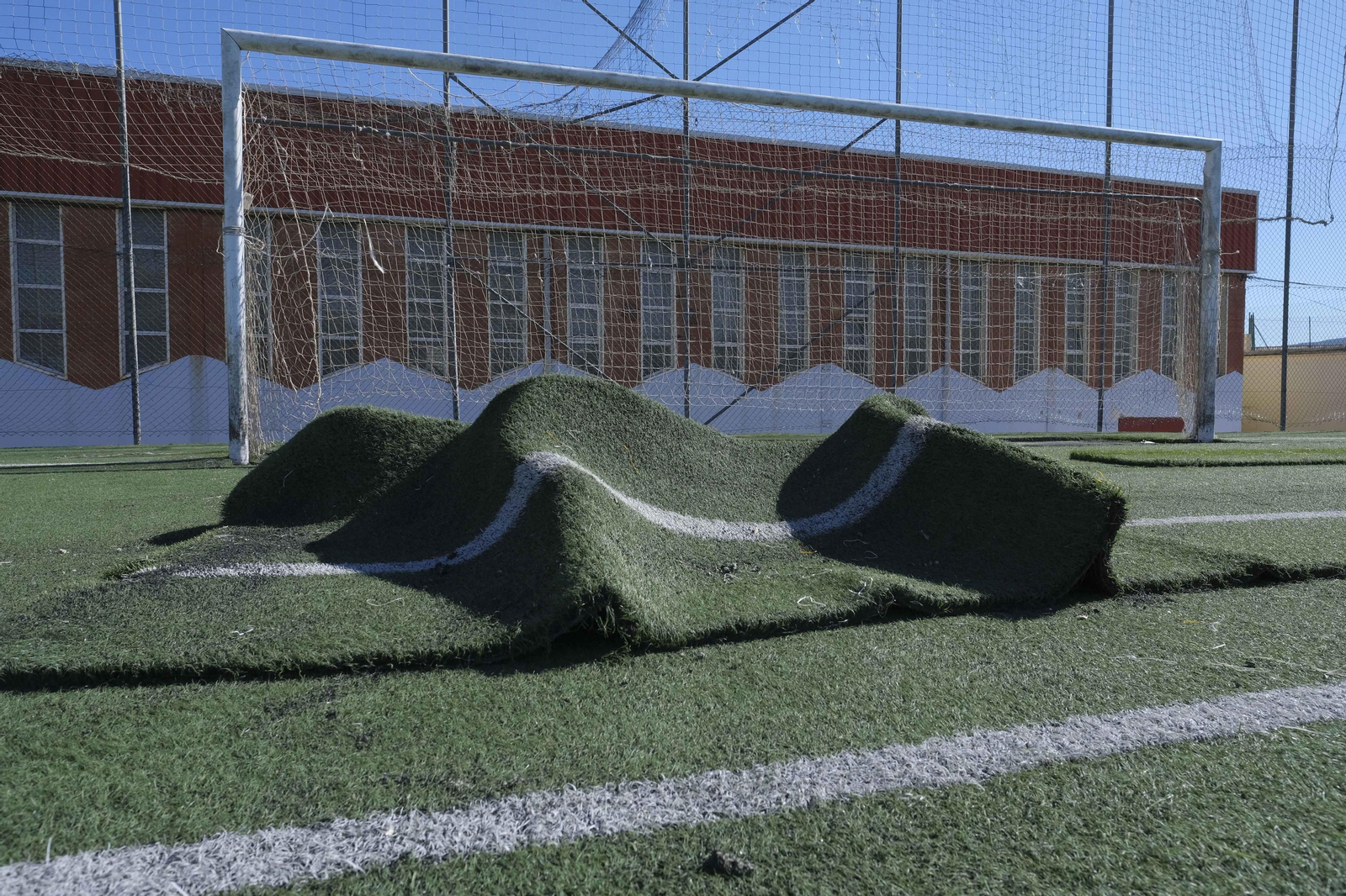 Trabajos de renovación del césped artificial en el complejo deportivo El Fuerte.