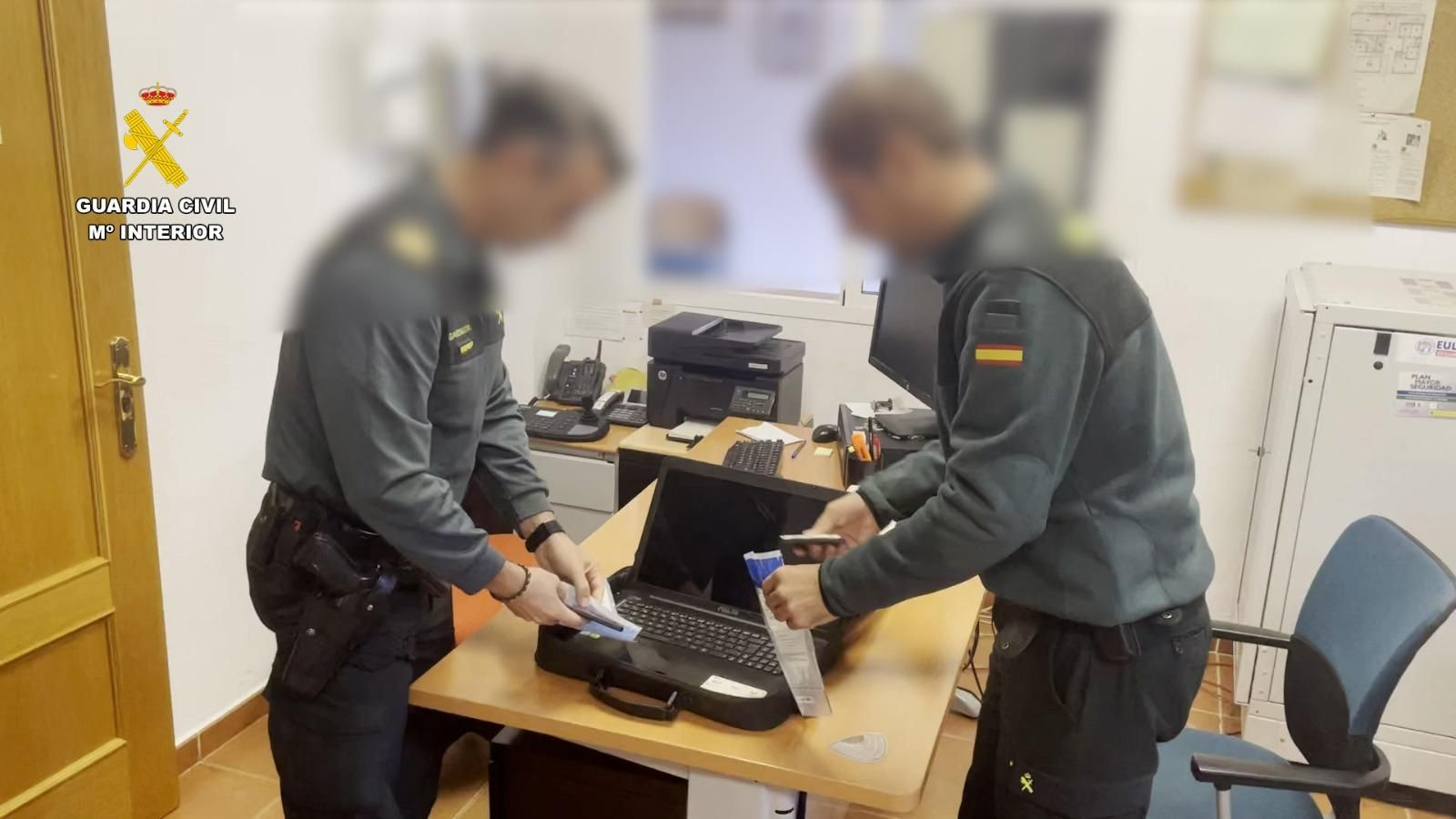Dos agentes de la Guardia Civil revisan el material incautado al detenido.