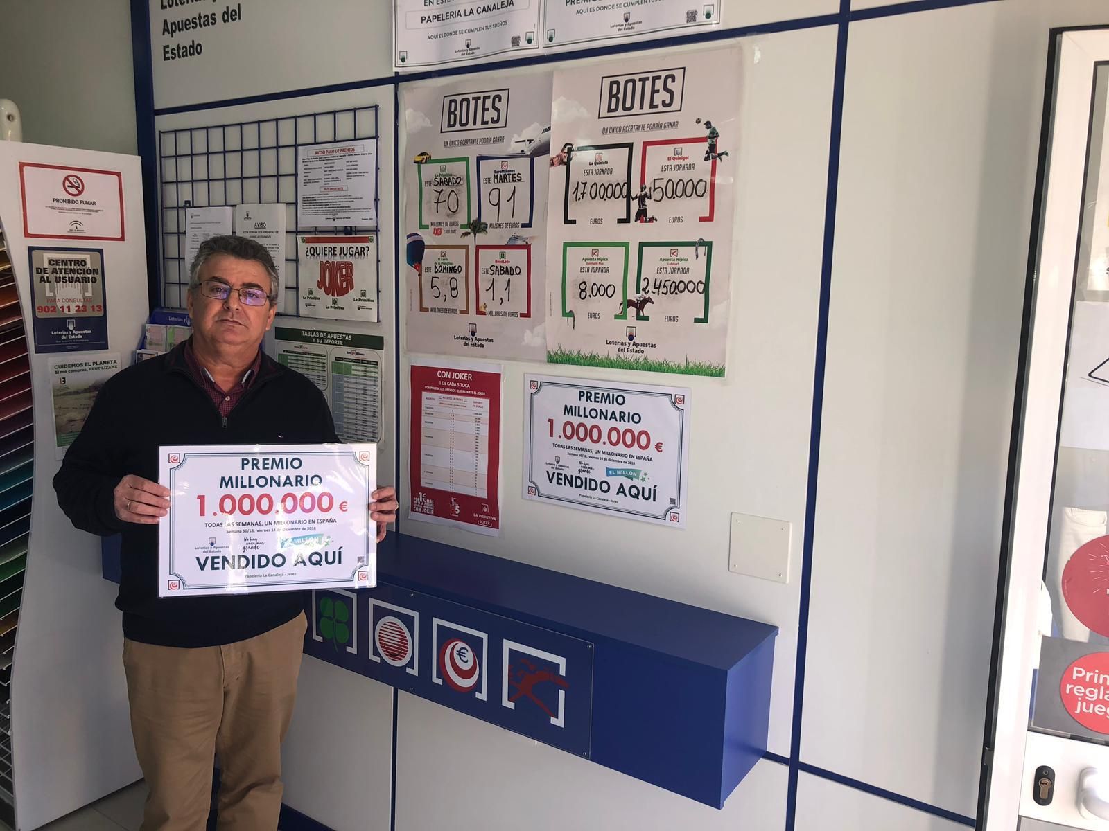 El propietario de la papelería La Canaleja con el cartel acreditativo del premio