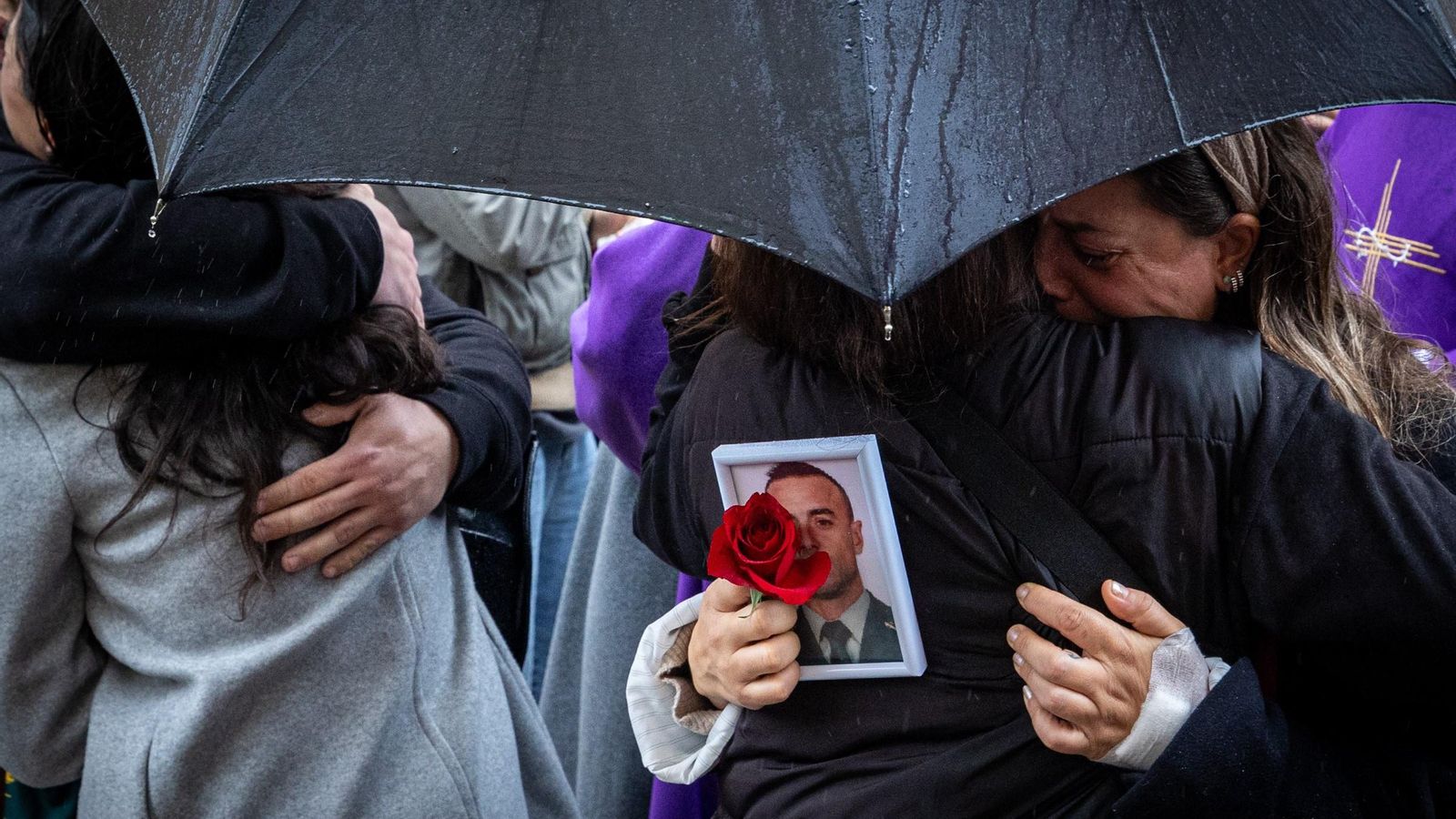 Familiares del agente gaditano fallecido en Barbate se abrazan durante el funeral.