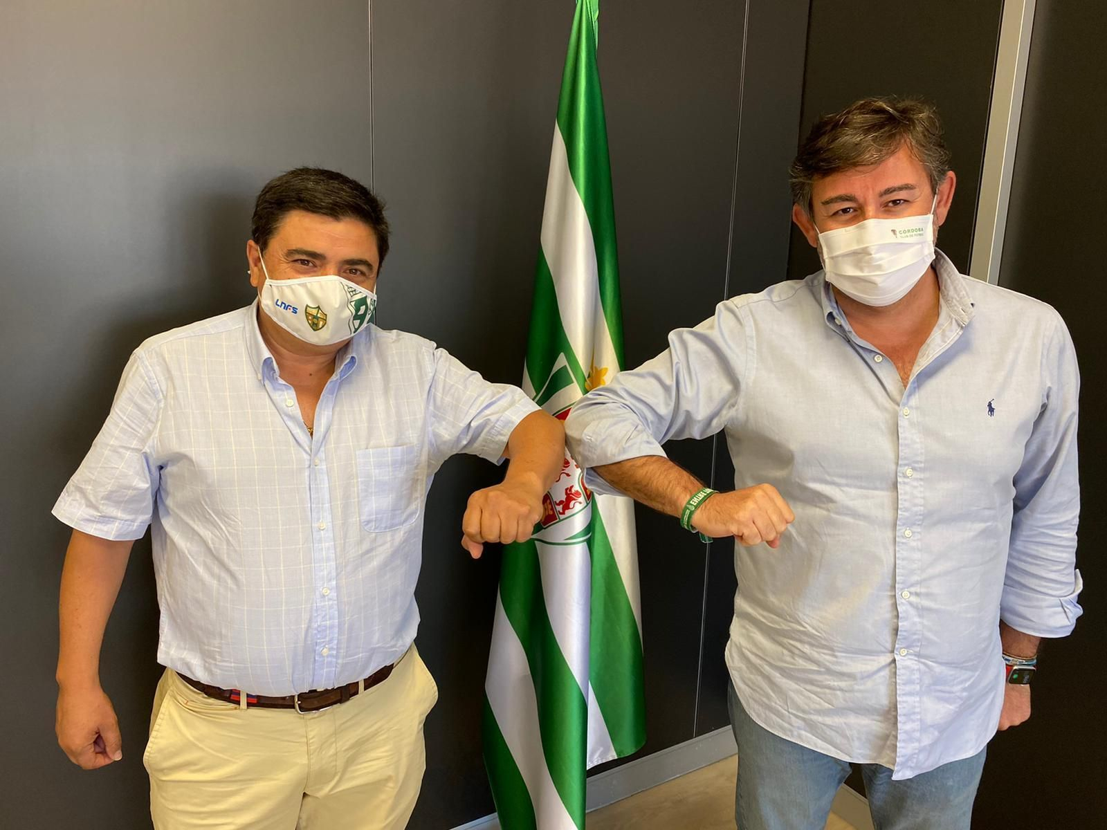 José García Román y Javier González Calvo chocan sus codos tras firmar su acuerdo de colaboración.