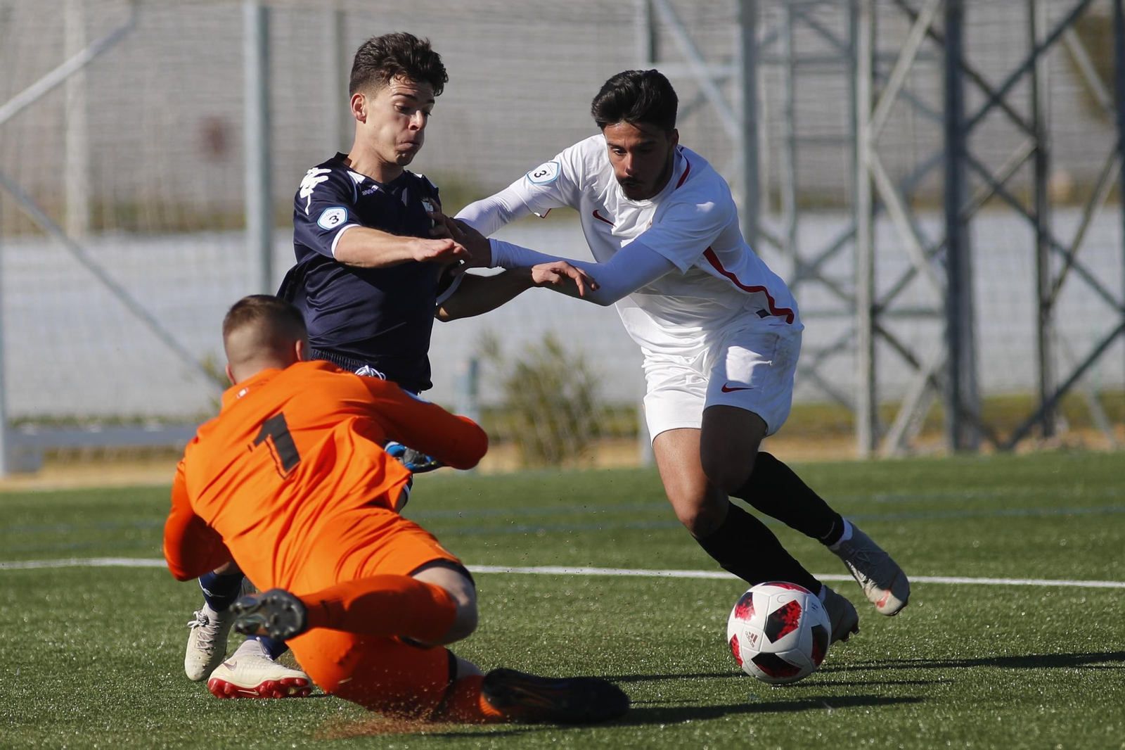 El algecirista Juanjo busca el balón ante el portero sevillista y un contrario.