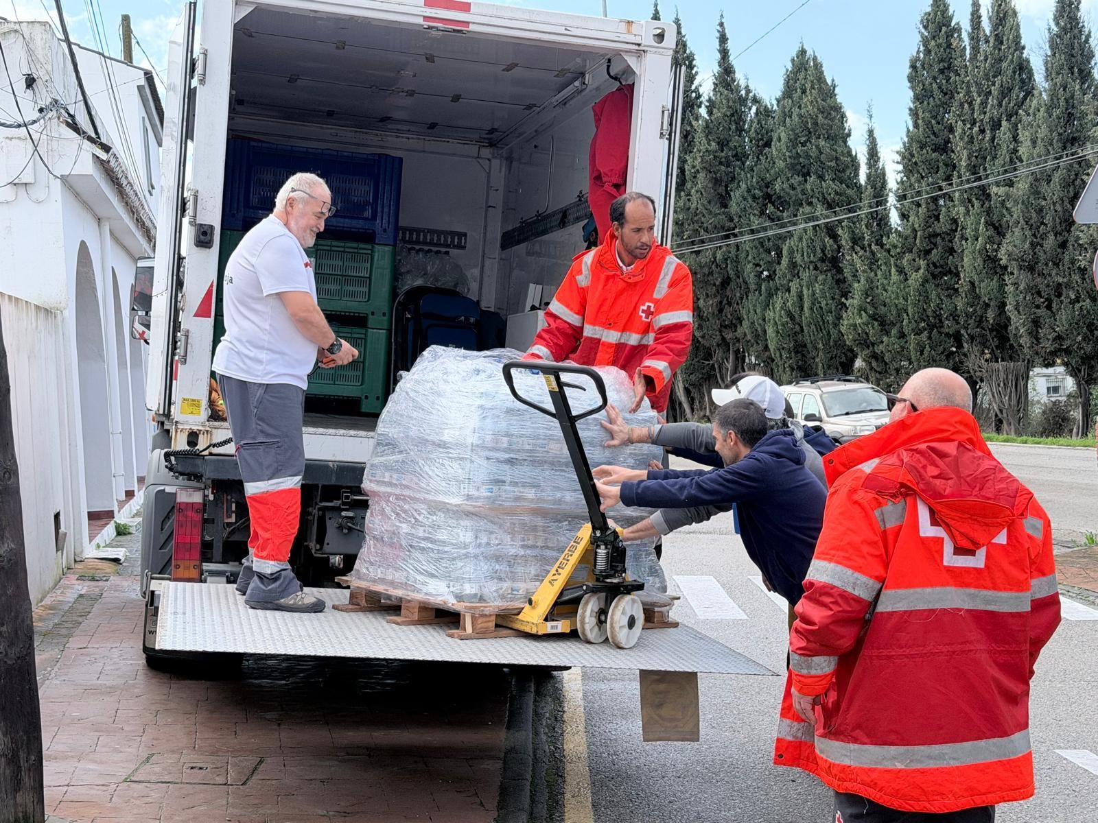 Personal de Cruz Roja descargando un camión con productos básicos.