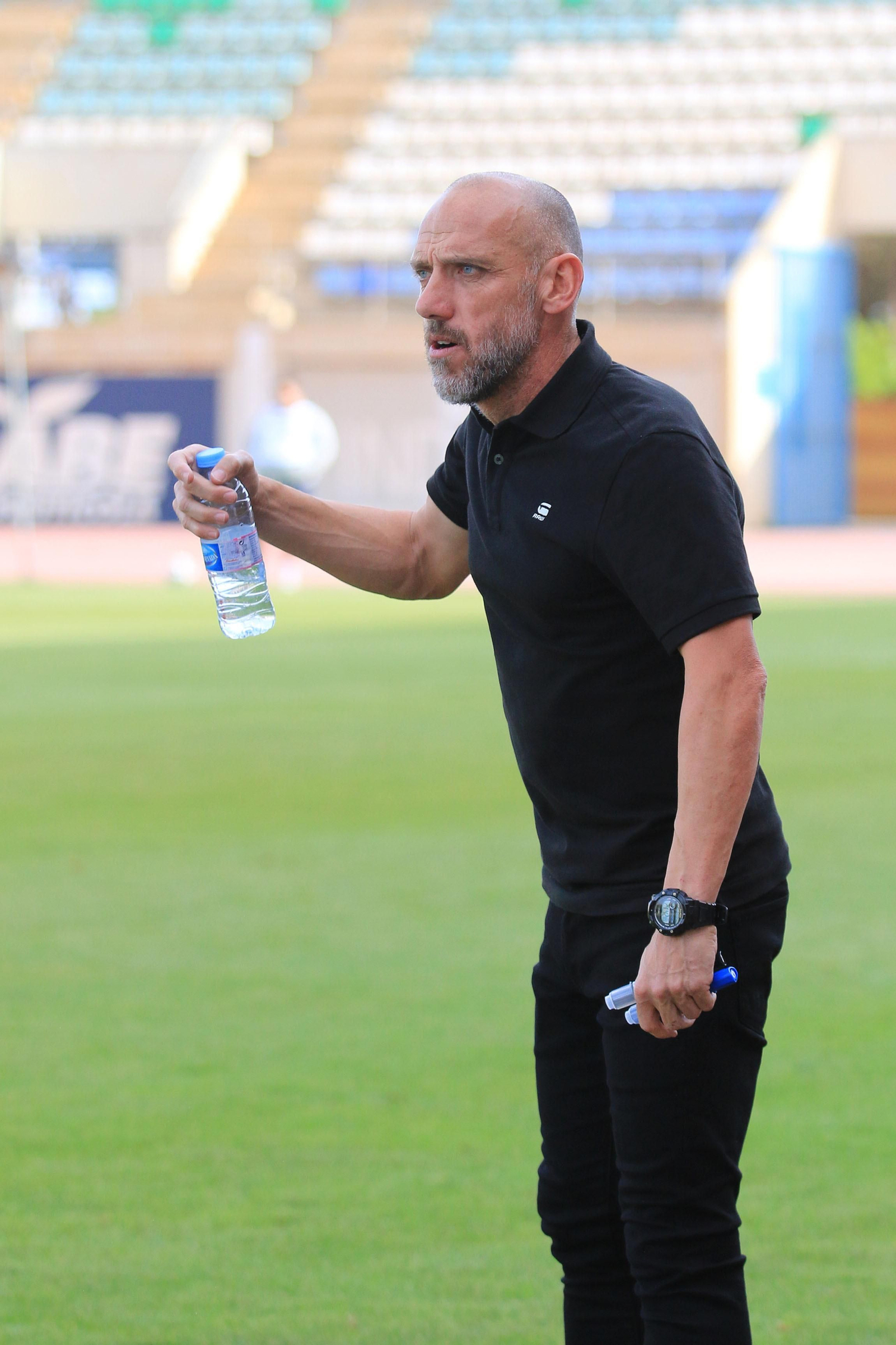 David Cabello sostiene una botella de agua mientras observa el partido de su equipo.