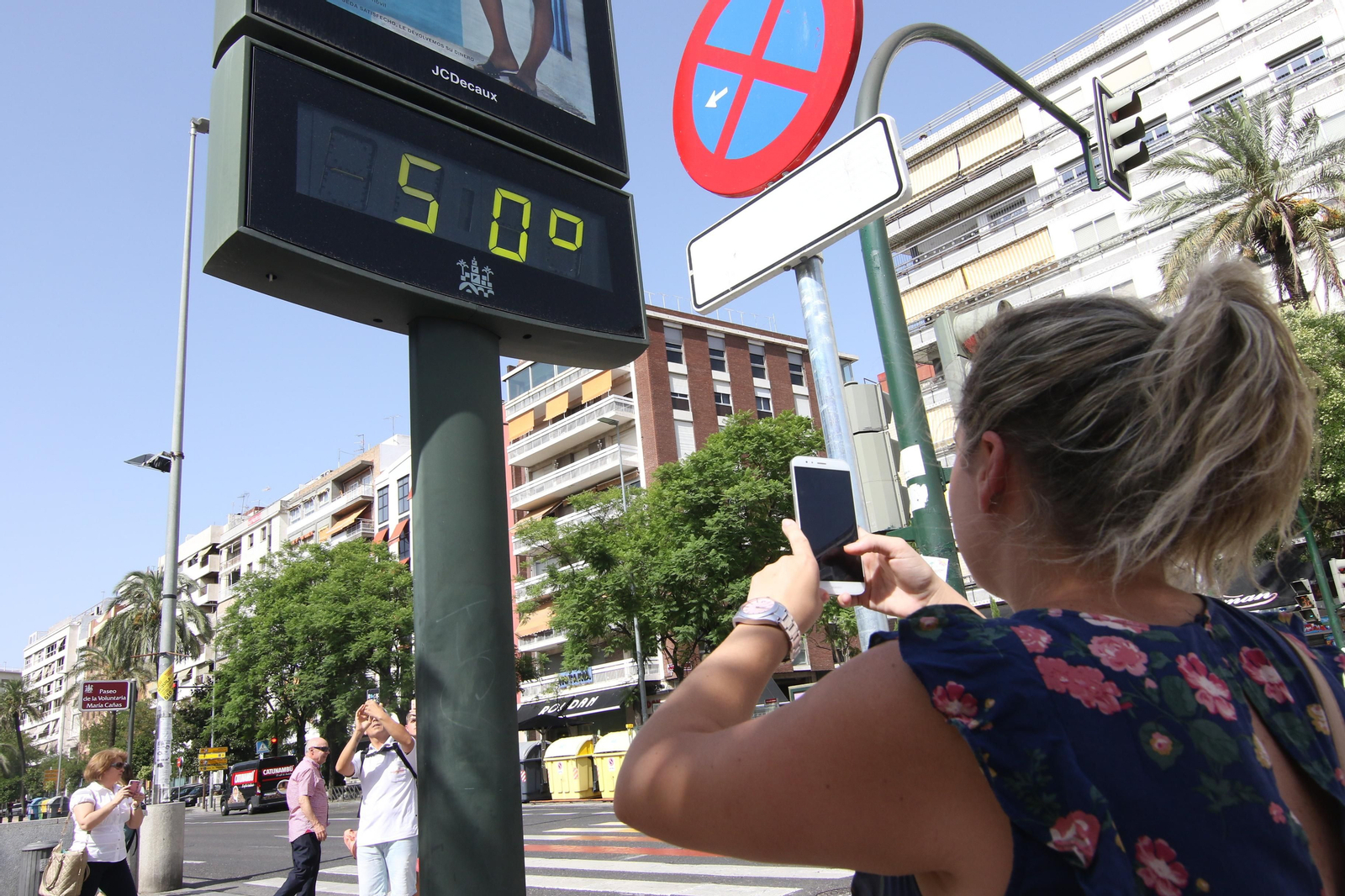 Una joven fotografía un termómetro del Paseo de la Victoria que alcanza los 50º C al sol.