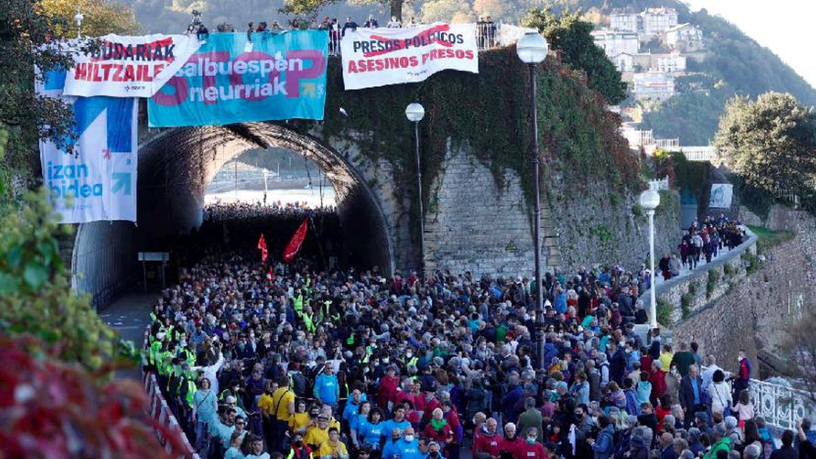 Paso de la manifestación por un puente con pancartas.
